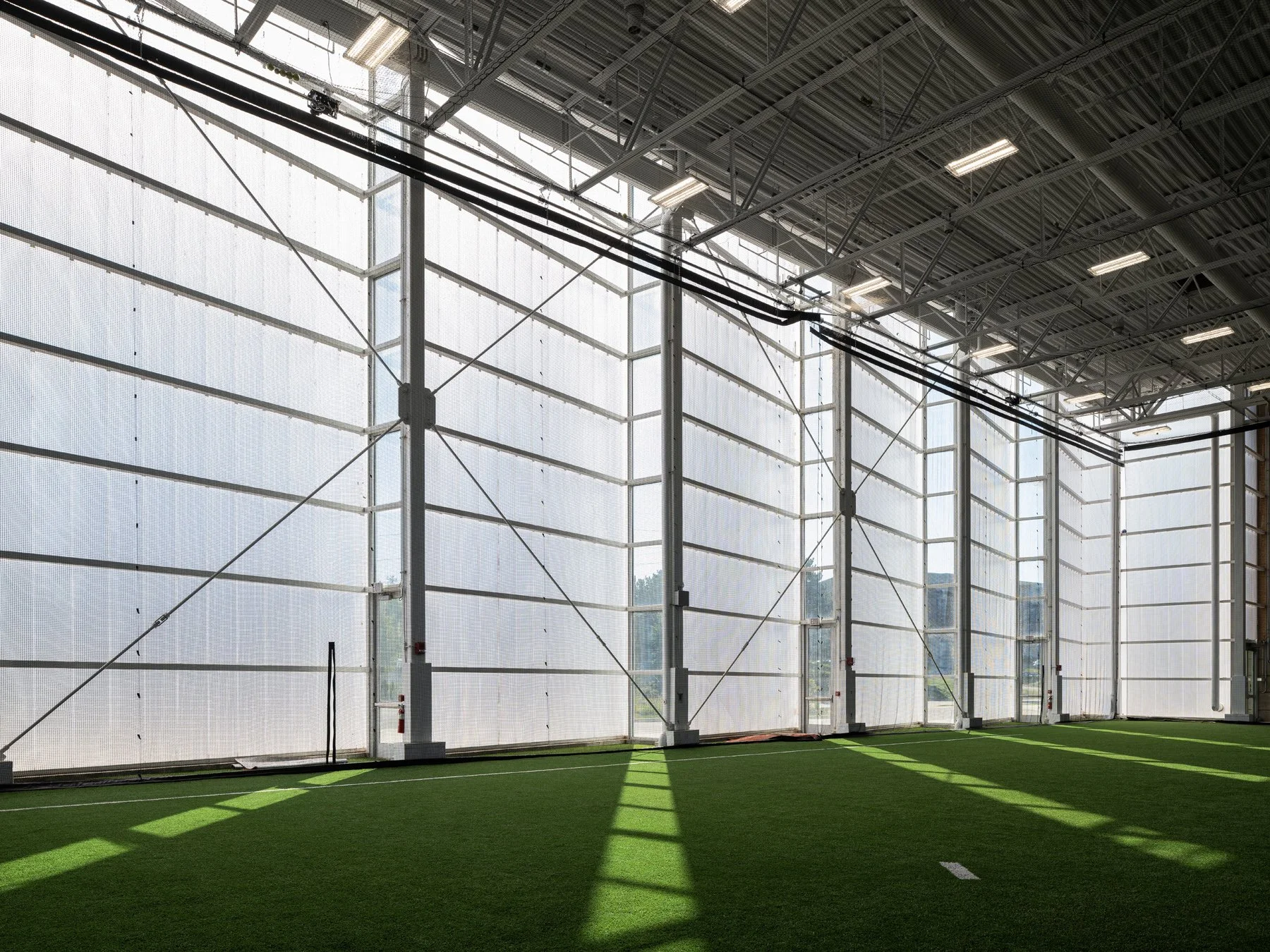 Beloit College Powerhouse field house interior with turf and a glowing translucent wall, by Studio Gang - architectural photographer Beloit Wisconsin