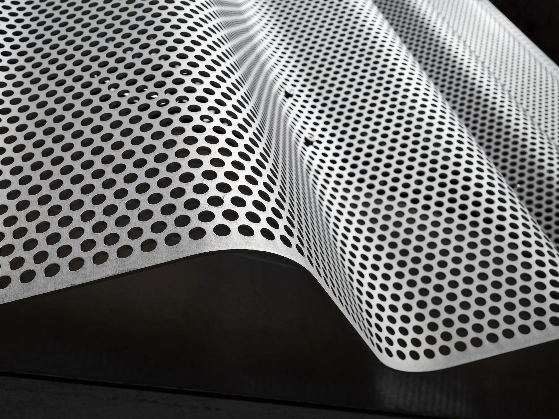 9 Chapel perforated aluminum cladding detail showing circular punched holes and curved wave profile at panel joint, by SO–IL - architectural photographer New York