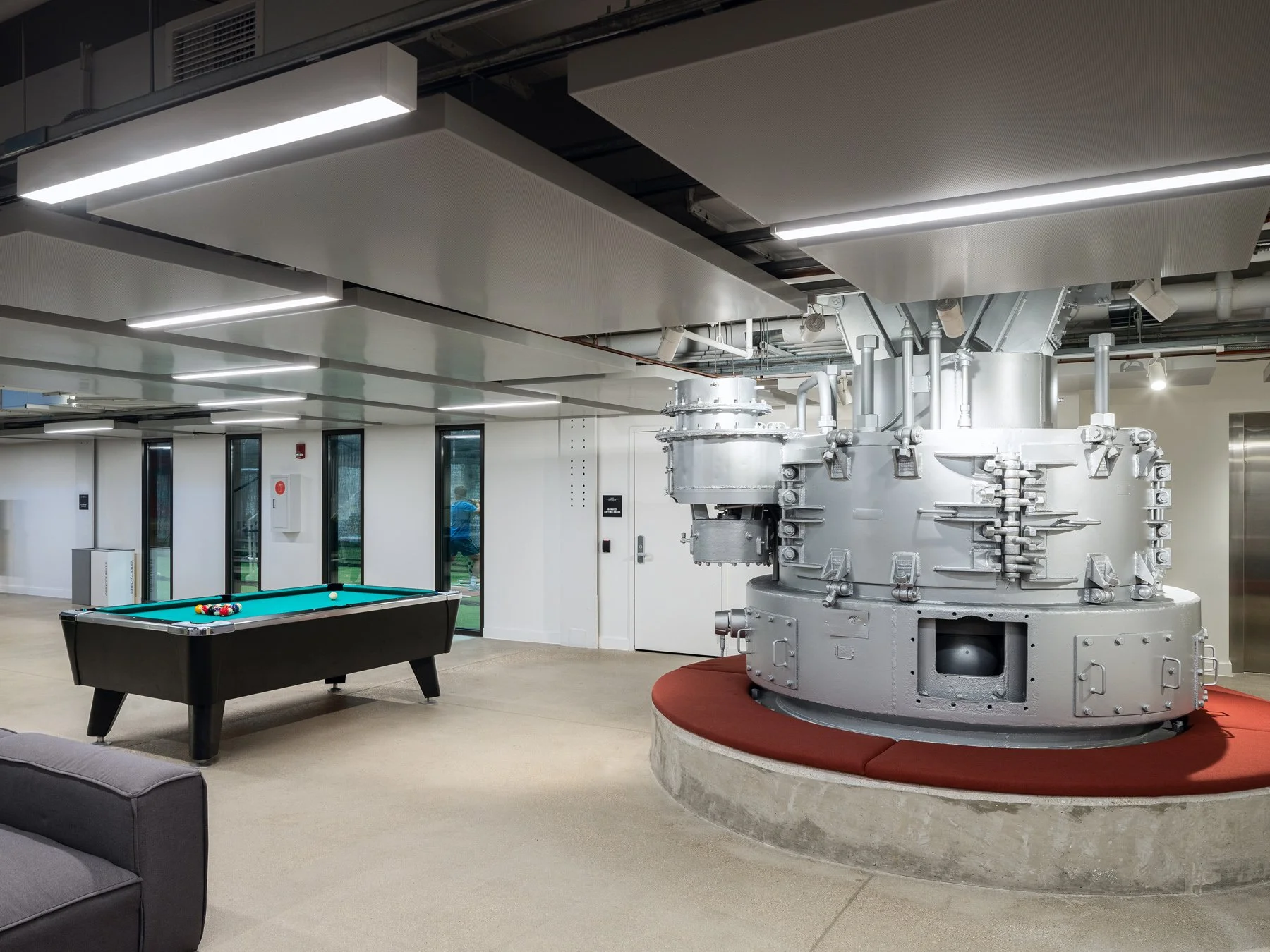 Beloit College Powerhouse lounge billiards table and a salvaged turbine on a red plinth, by Studio Gang - architectural photographer Beloit Wisconsin