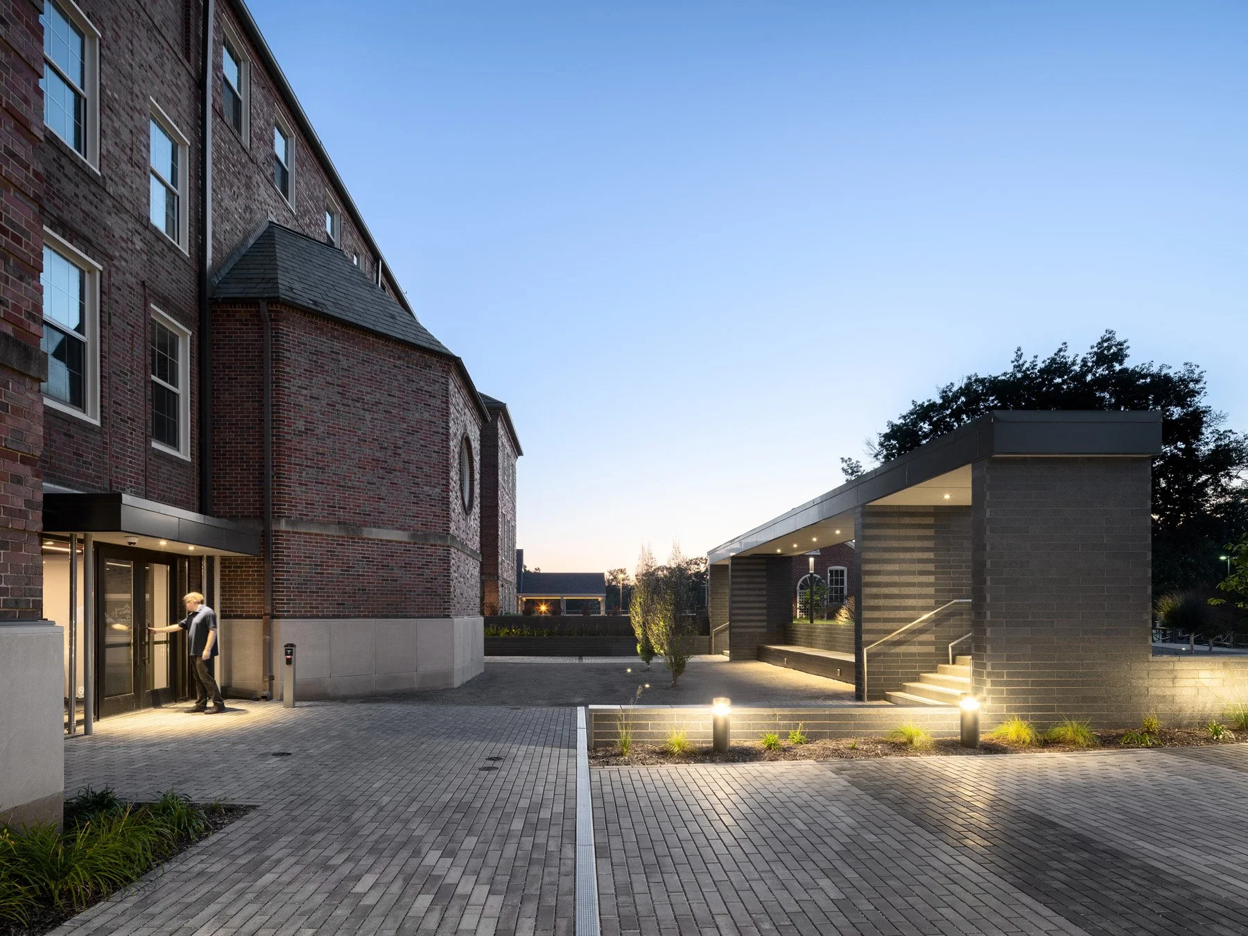 St. Louis architectural photography of a civic building at dusk, a brick original with a contemporary board-formed concrete addition.