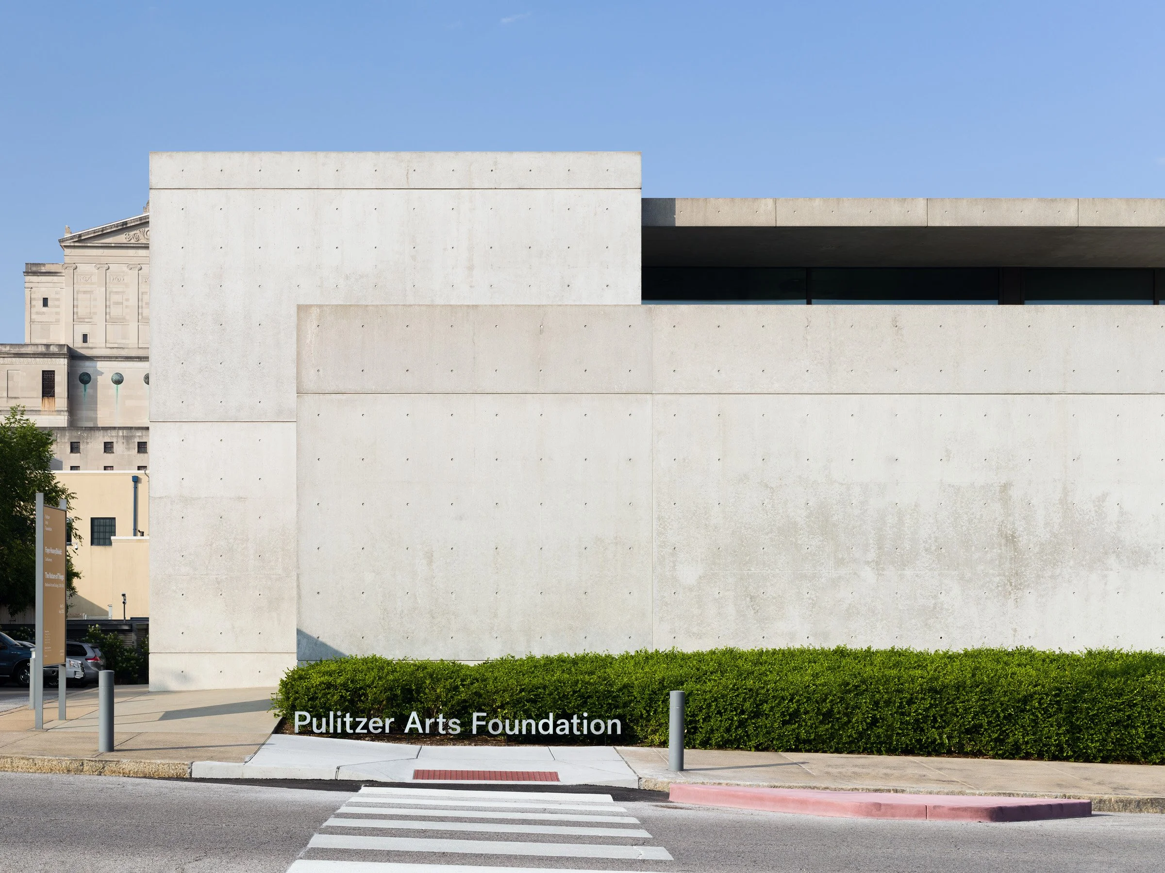 Pulitzer Arts Foundation exterior by day with the cast-in-place concrete street wall carrying the foundation's name in raised lettering above the crosswalk, by Tadao Ando, St. Louis Missouri - architectural photographer St. Louis Missouri