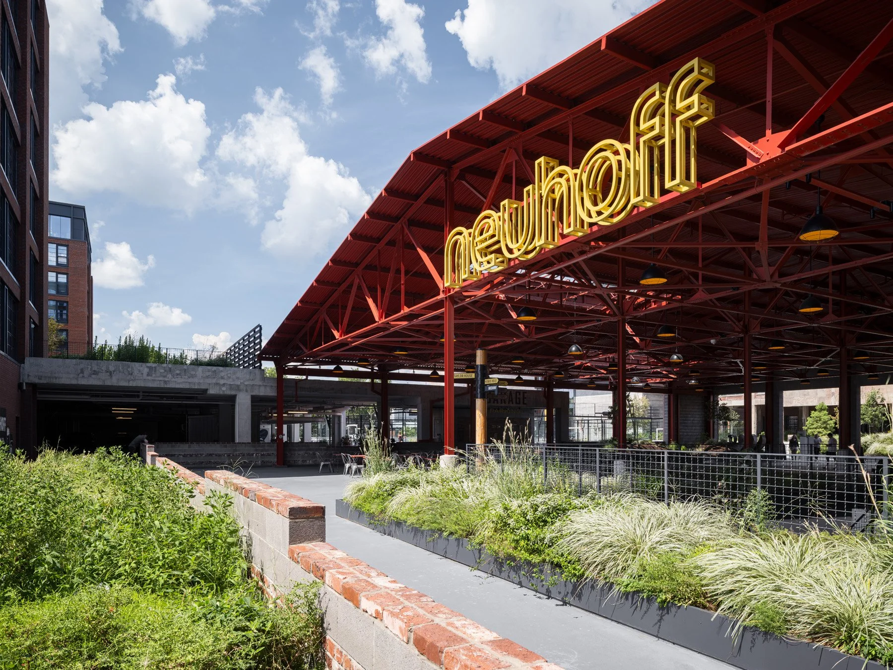 Neuhoff District yellow neon sign under the red steel shed canopy, signage by Airspace - architectural photographer Nashville Tennessee