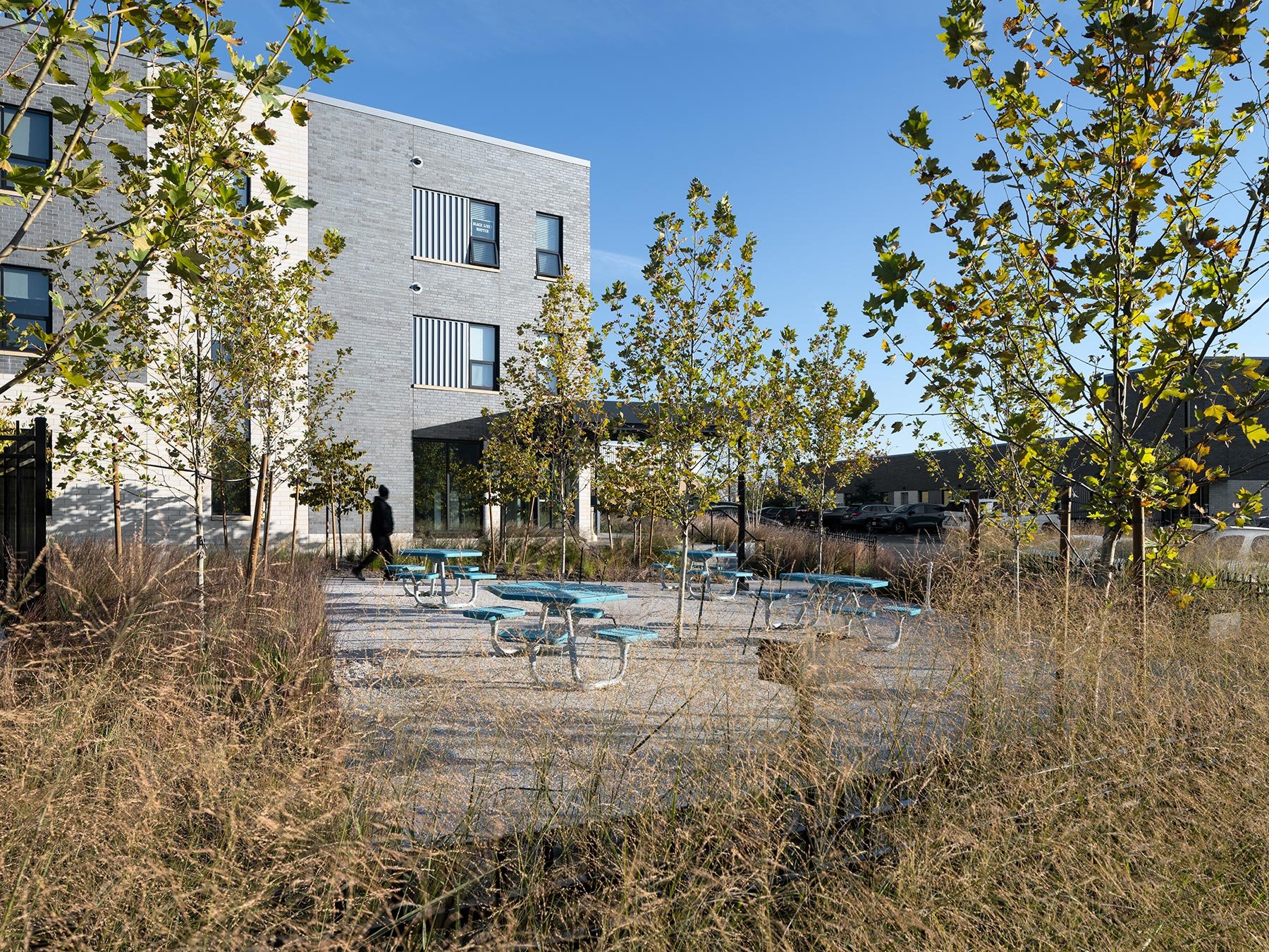 DOORWAYS housing wing corner with picnic tables and plantings, by Trivers - architectural photographer St. Louis Missouri