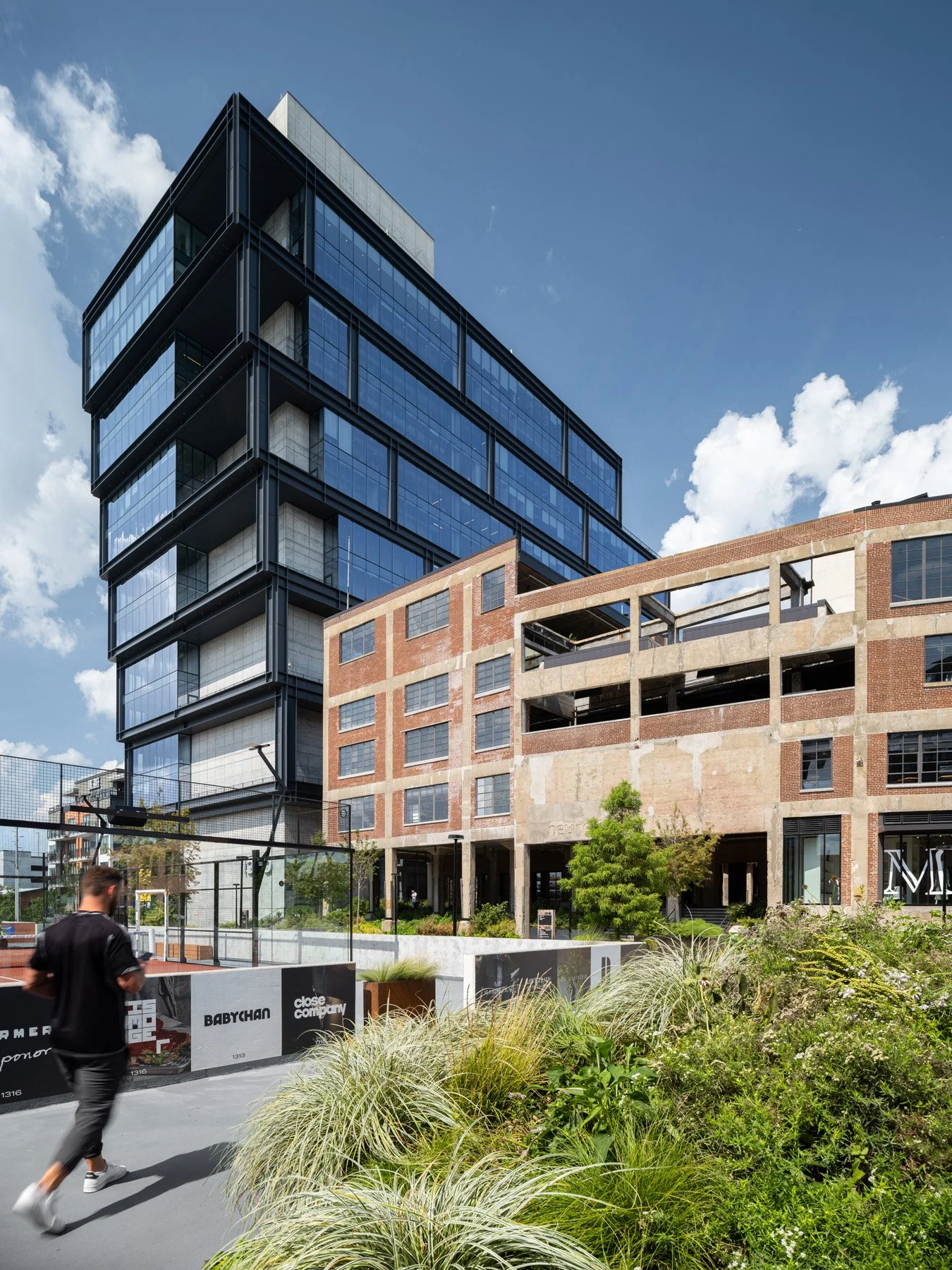 Neuhoff District glass office tower by S9 Architecture beside the Curve by Smith Gee Studio - architectural photographer Nashville Tennessee