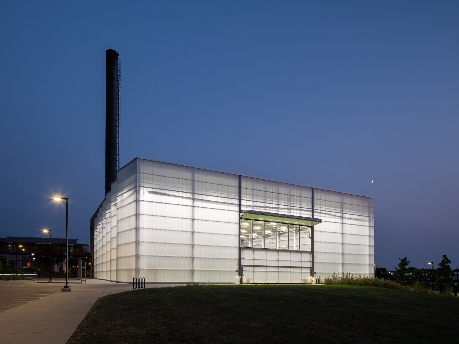 Beloit College Powerhouse glowing field house at dusk with smokestack and crescent moon, by Studio Gang - architectural photographer Beloit Wisconsin