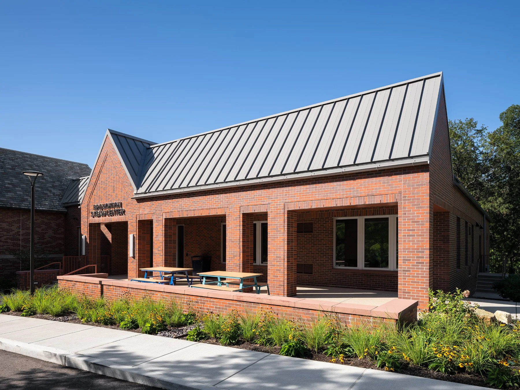 Broughton STEAM Center exterior brick wing with steep metal roof and covered porch, by Christner - architectural photographer St. Louis Missouri