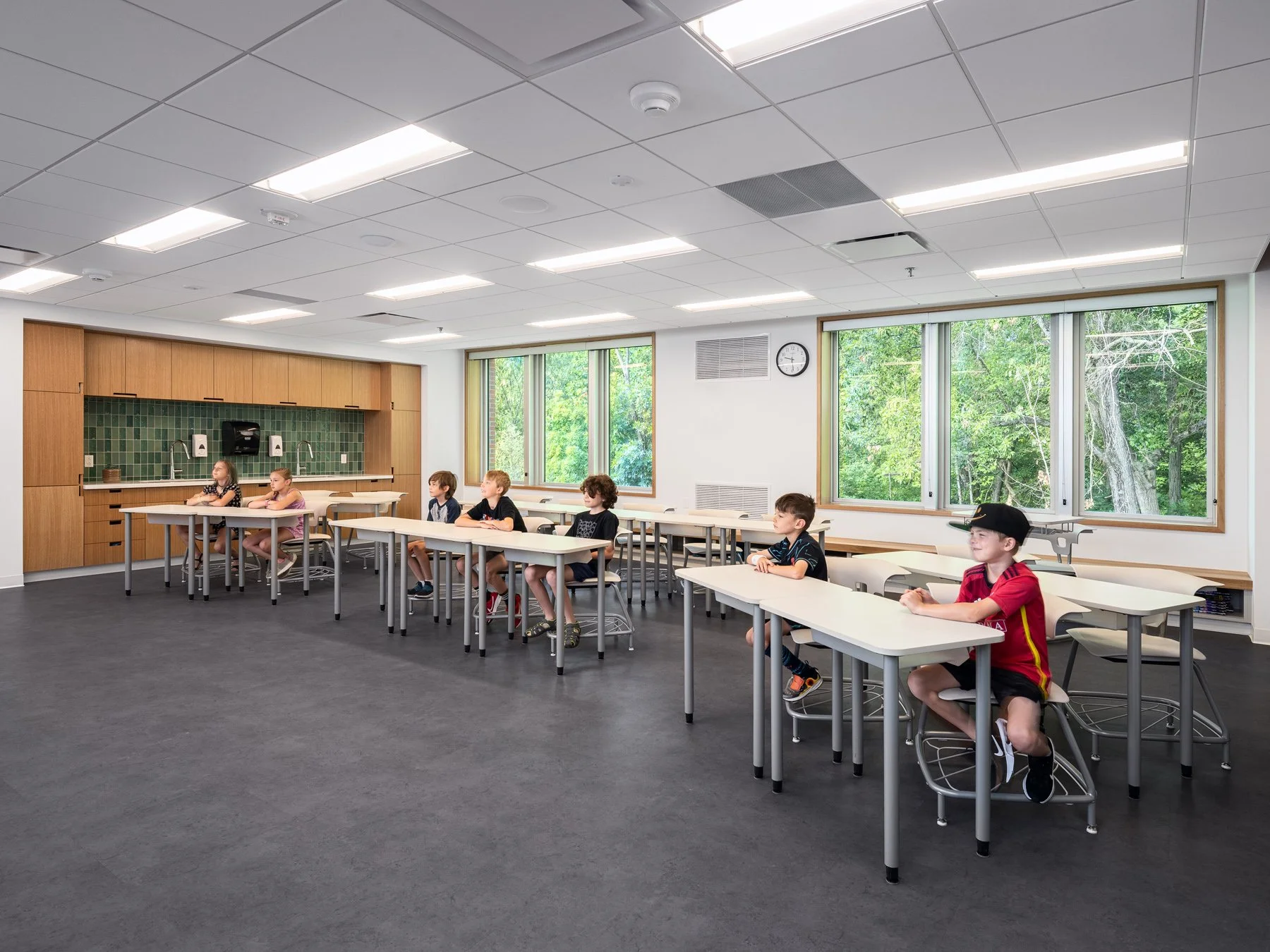 Broughton STEAM Center interior classroom with rows of desks and windows onto the woods, by Christner - architectural photographer St. Louis Missouri