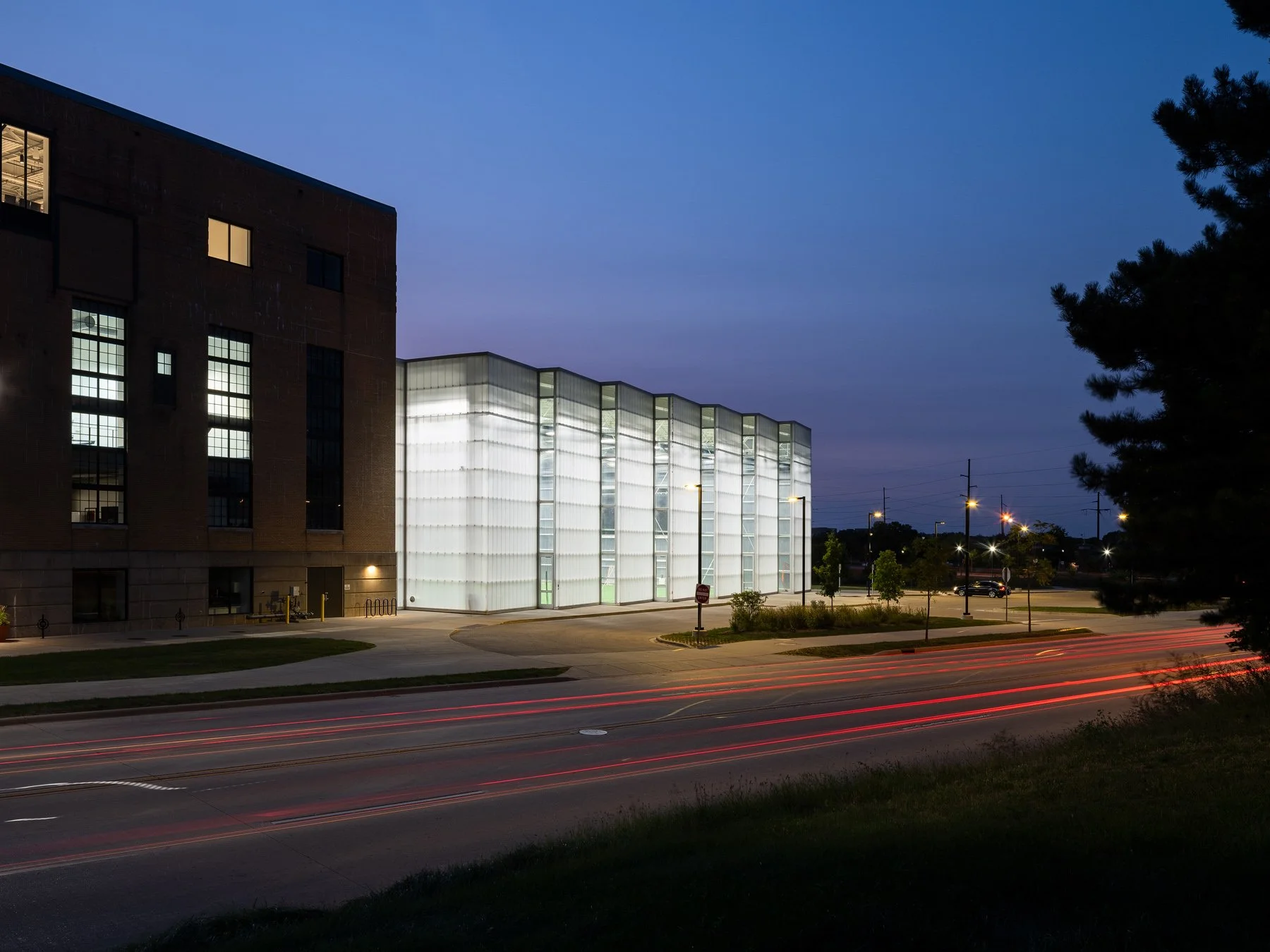 Beloit College Powerhouse illuminated field house at dusk above red car light trails, by Studio Gang - architectural photographer Beloit Wisconsin
