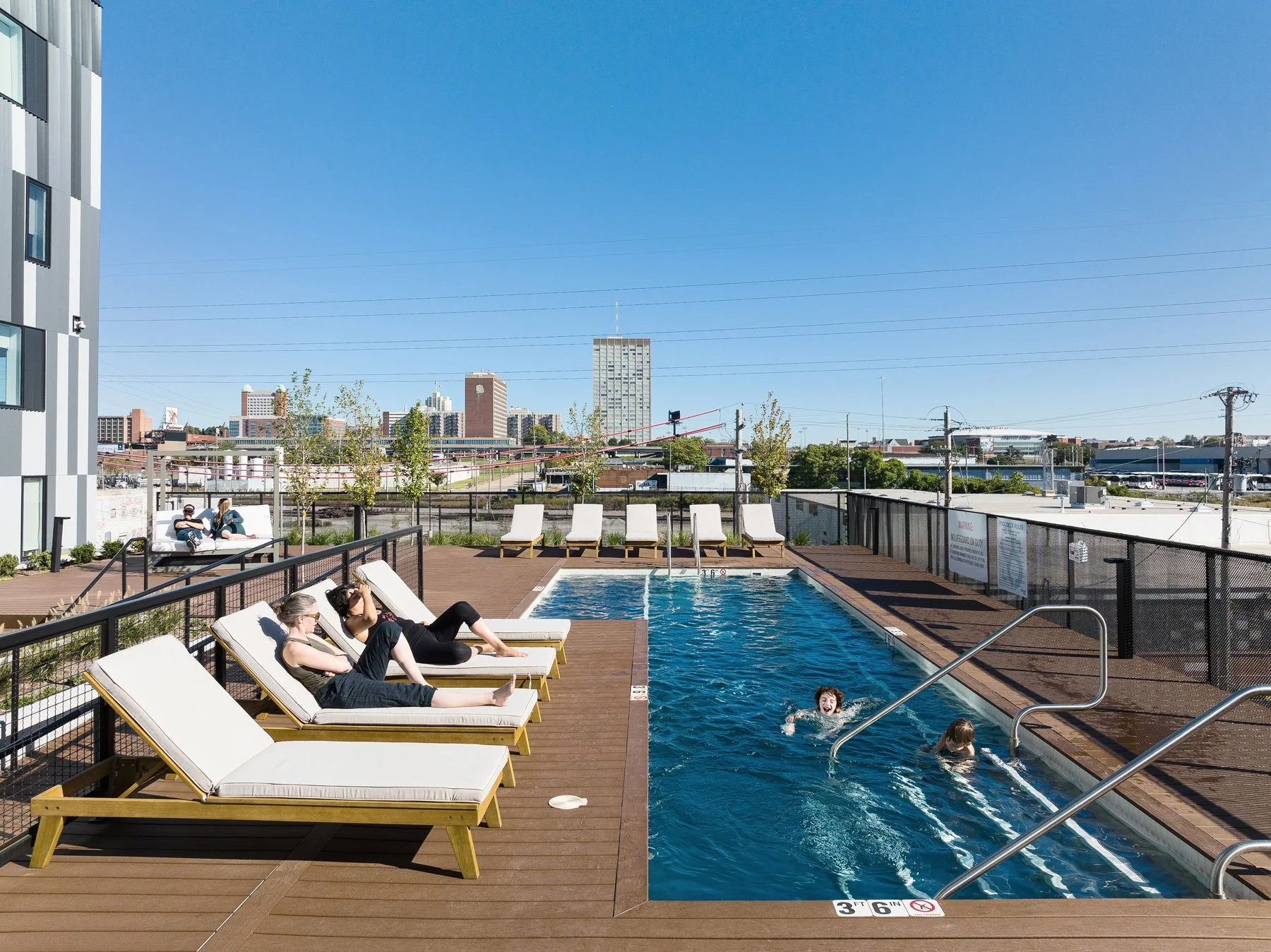 Steelcote Flats amenity pool and loungers above the surrounding city skyline, by Trivers - architectural photographer St. Louis Missouri