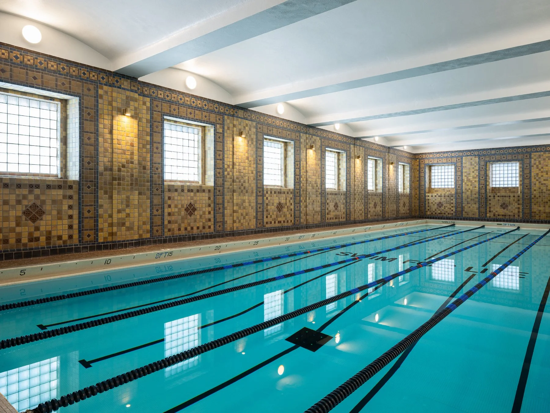 Locust Street Athletic and Swim Club interior lap pool with its Swim for Life mosaic and historic tile walls, at the 21c Museum Hotel by Perfido Weiskopf Wagstaff + Goettel with tile by Rookwood Pottery - architectural photographer St. Louis Missouri