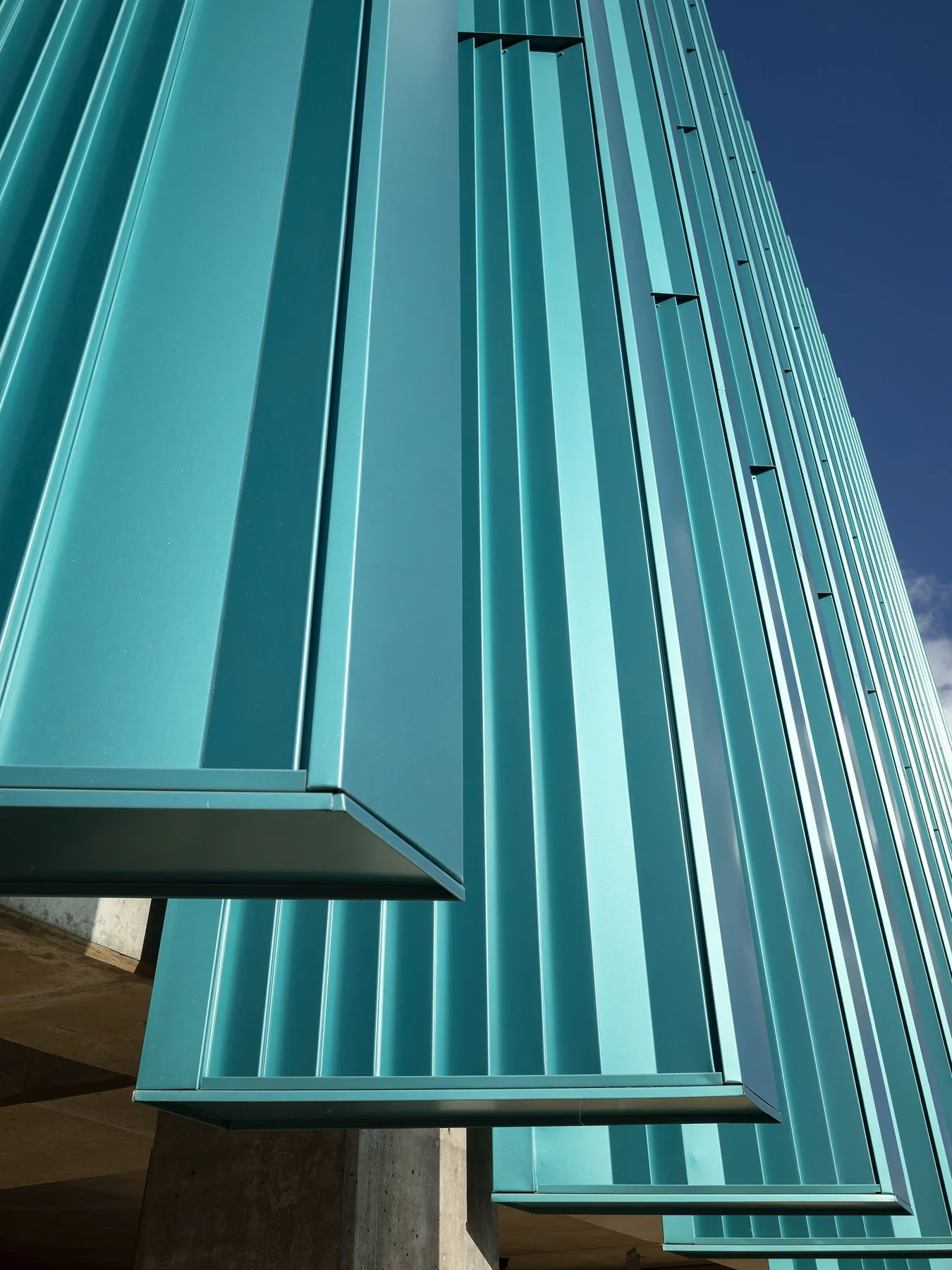 Crystal Bridges Parking looking up the teal metal fins against blue sky, by Marlon Blackwell - architectural photographer Bentonville Arkansas
