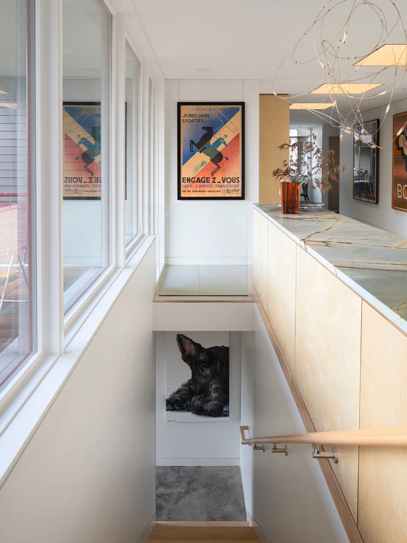 Monty Residence interior stair landing with framed posters and plywood cabinetry, by Studio Lark - architectural photographer St. Louis Missouri