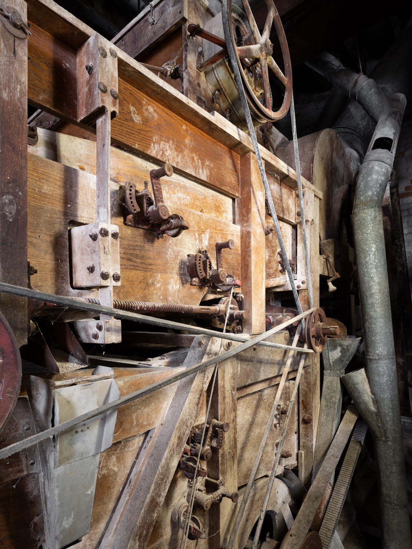 Millstadt Mill wood-cased roller mill with cast-iron feed-adjustment levers along the front, belt-driven - architectural photographer St. Louis Missouri