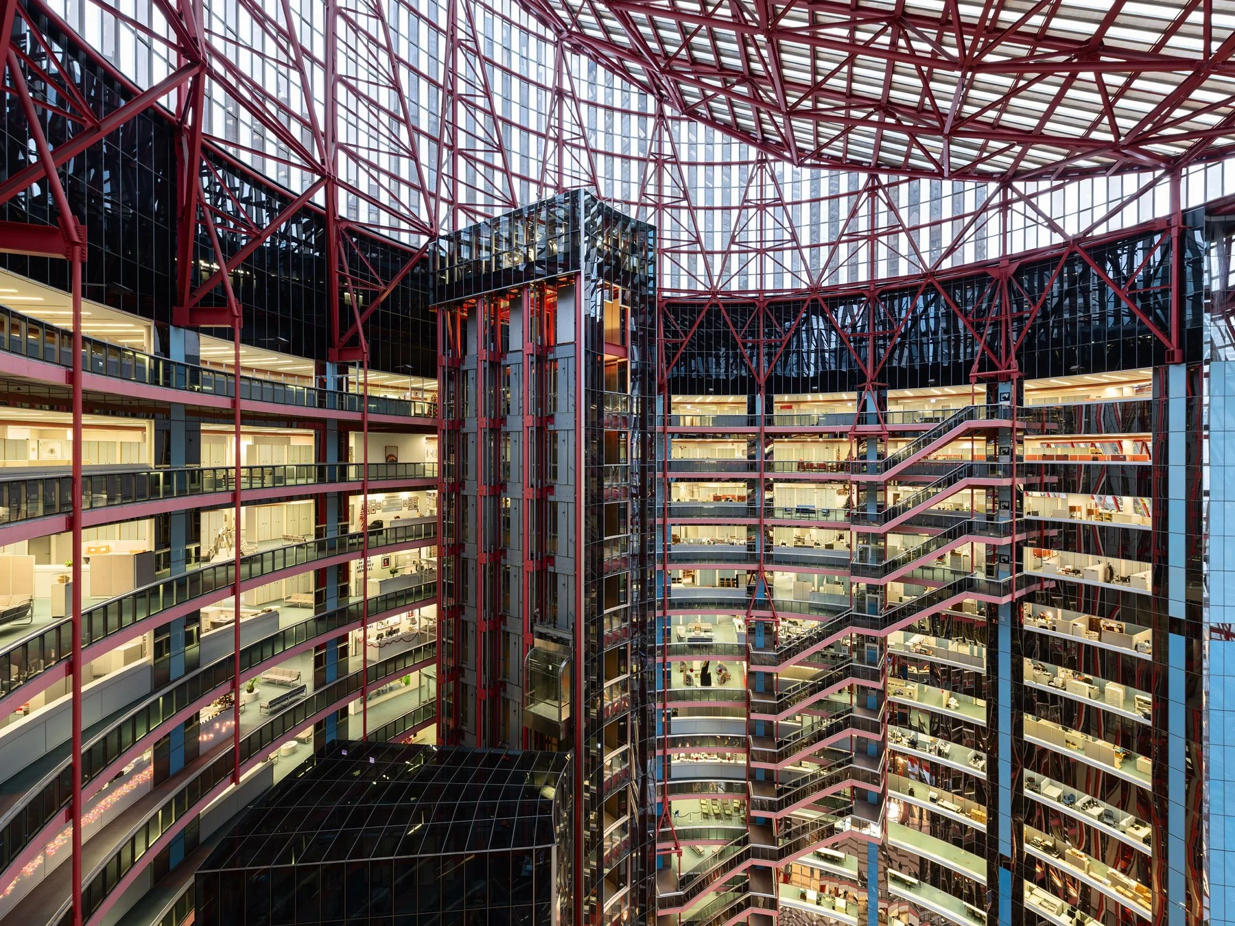 James R. Thompson Center upper atrium at dusk, lit office cubicles along the curving tiers, Chicago - government offices interior