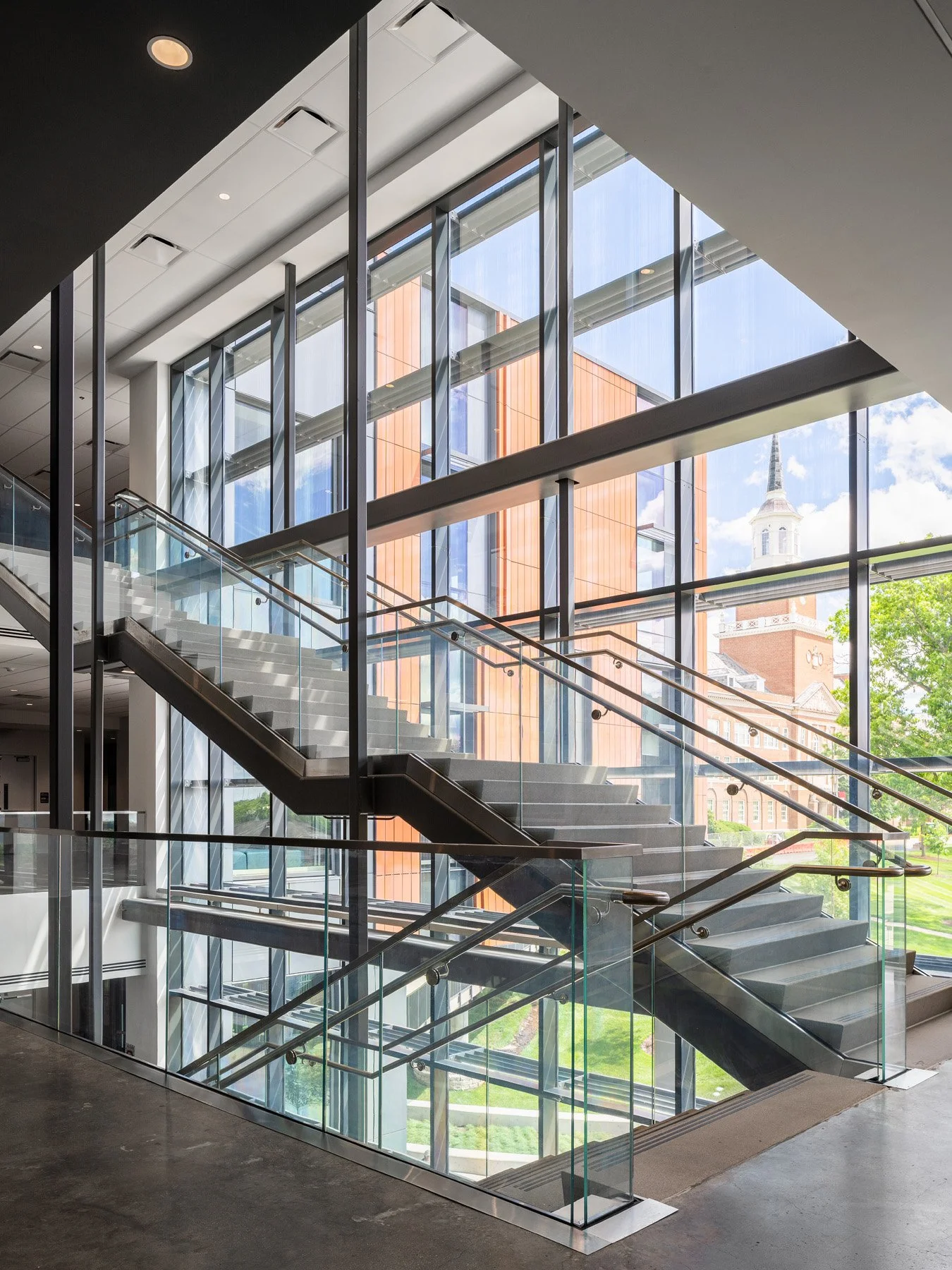 Clifton Court Hall interior stair framed by glazing with campus tower beyond, by LMN Architects and KZF Design - architectural photographer Cincinnati Ohio