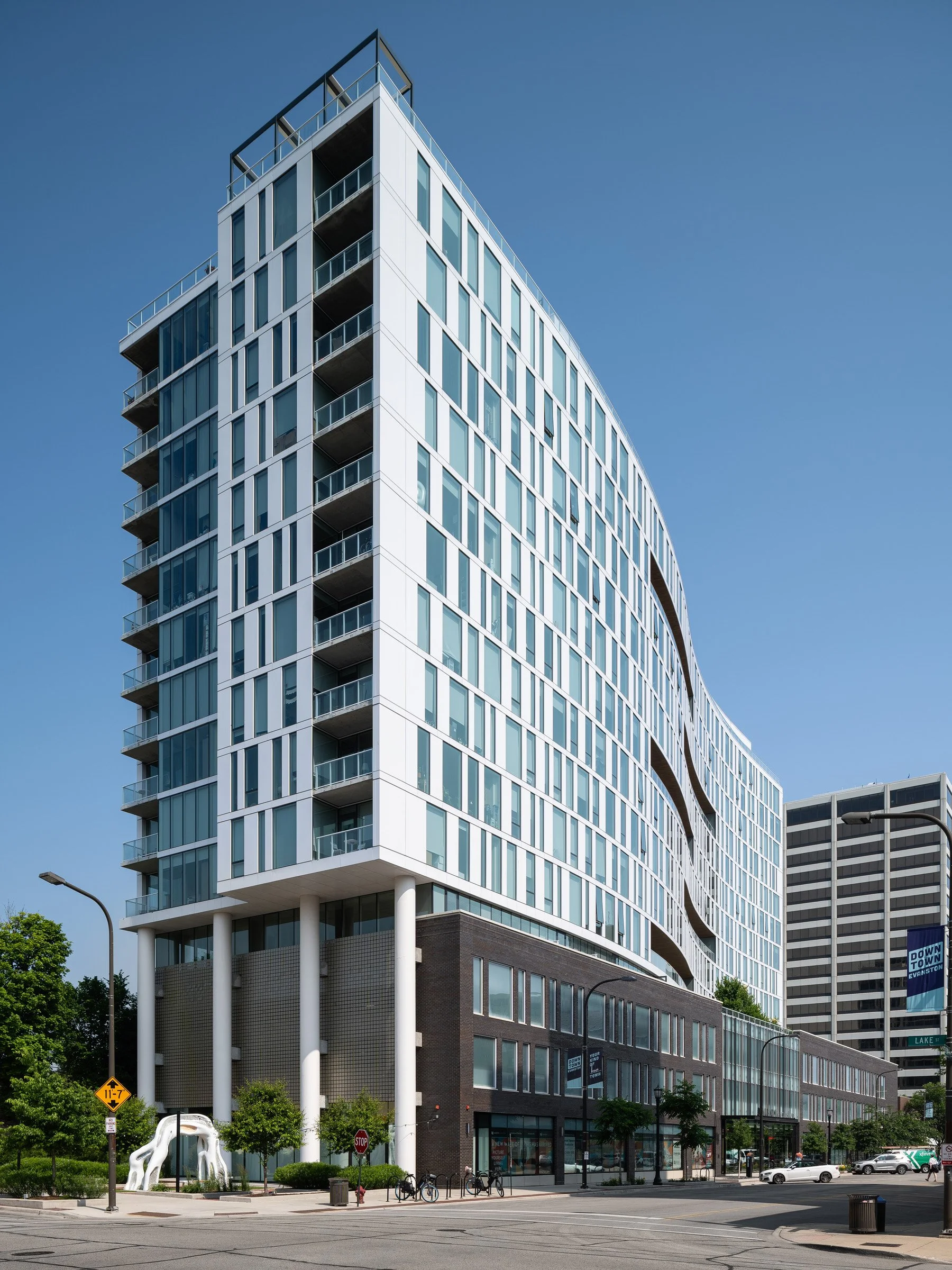 Albion Evanston exterior with the residential tower lifted on slender columns above its base near Lake Street, by Hartshorne Plunkard Architecture, Evanston Illinois - architectural photographer Chicago Illinois