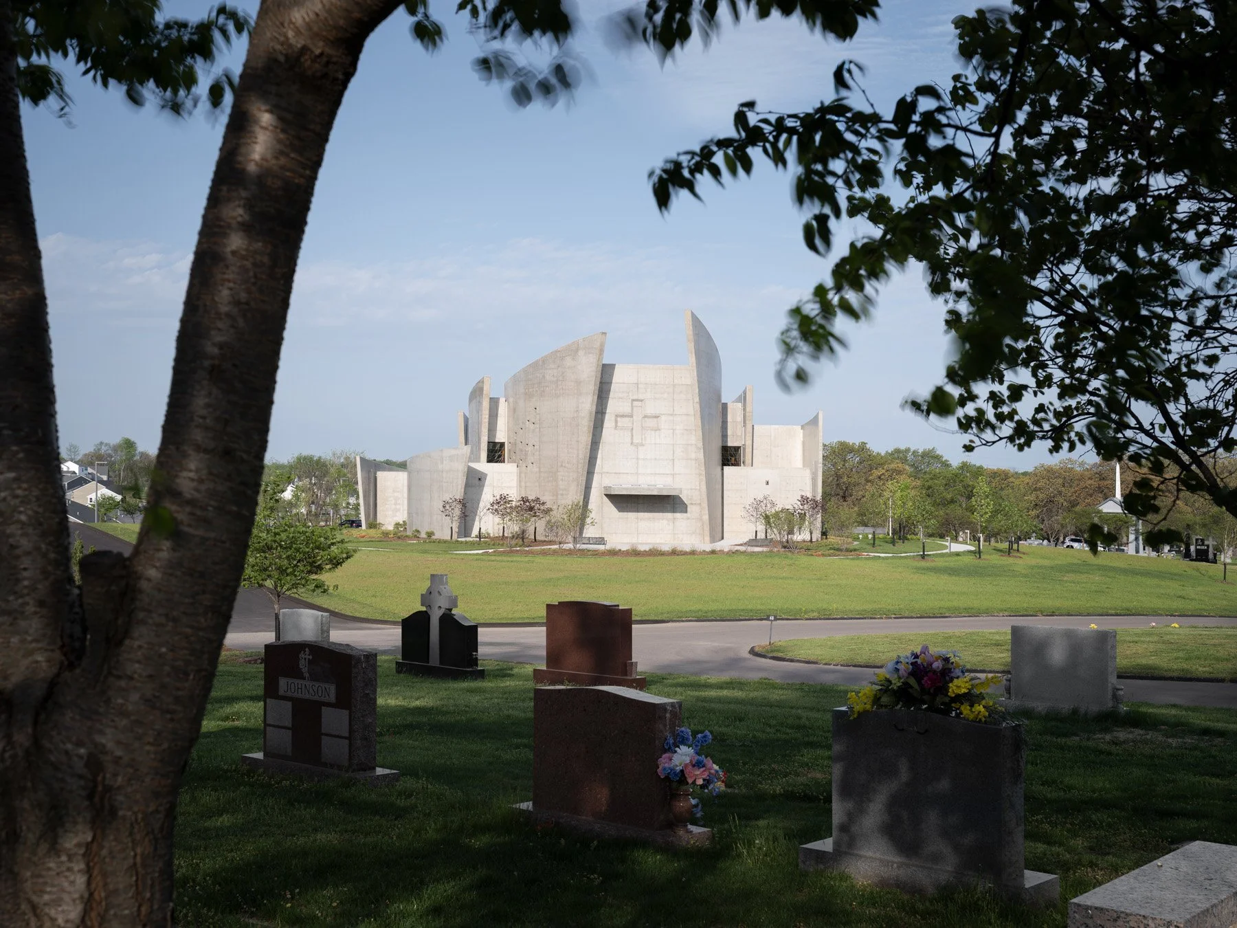 Chapel of the Risen Christ across the cemetery beyond gravestones, by Design Alliance Architects - architectural photographer St. Louis Missouri