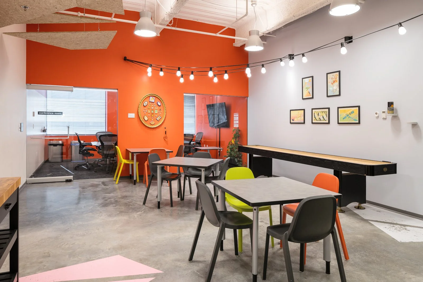 4220 Duncan interior lounge with orange accent wall and shuffleboard table, by HOK - architectural photographer St. Louis Missouri