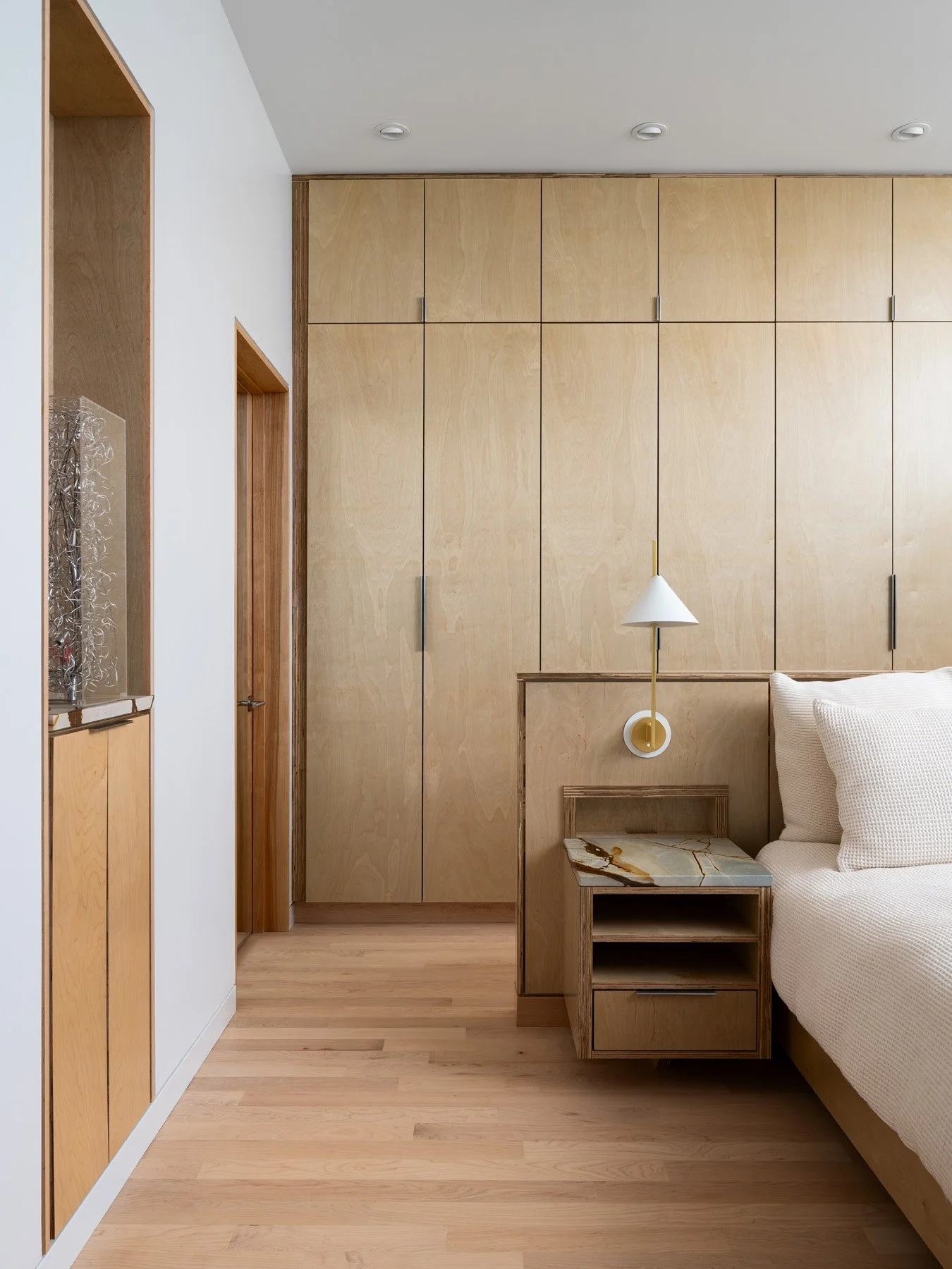 Monty Residence interior bedroom with a plywood wardrobe wall and nightstand, by Studio Lark - architectural photographer St. Louis Missouri