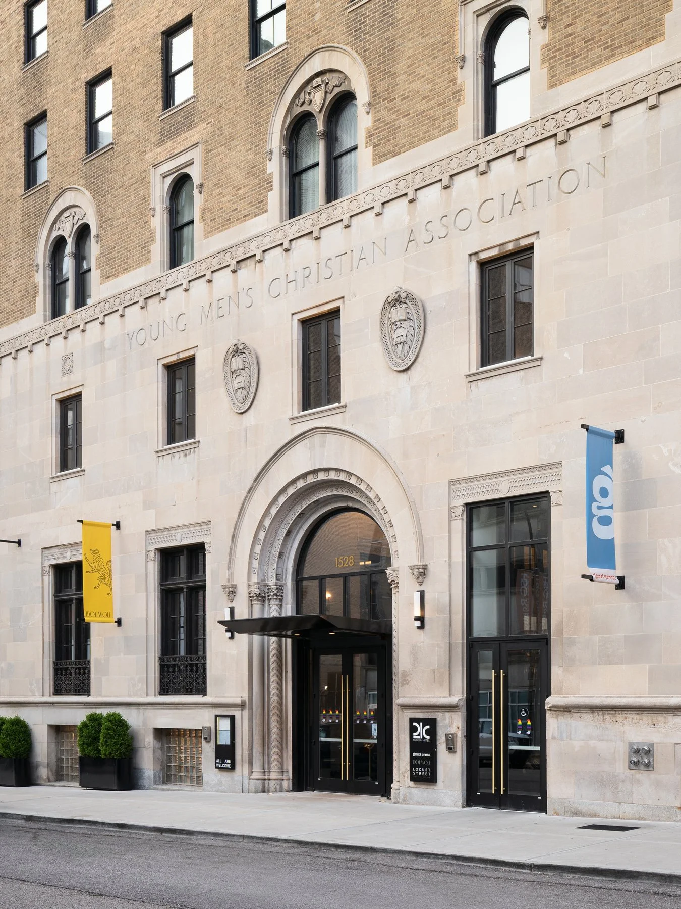 21c Museum Hotel exterior showing the carved limestone Young Men's Christian Association entrance and original brick facade at 1528 Locust Street, restored by Perfido Weiskopf Wagstaff + Goettel - architectural photographer St. Louis Missouri