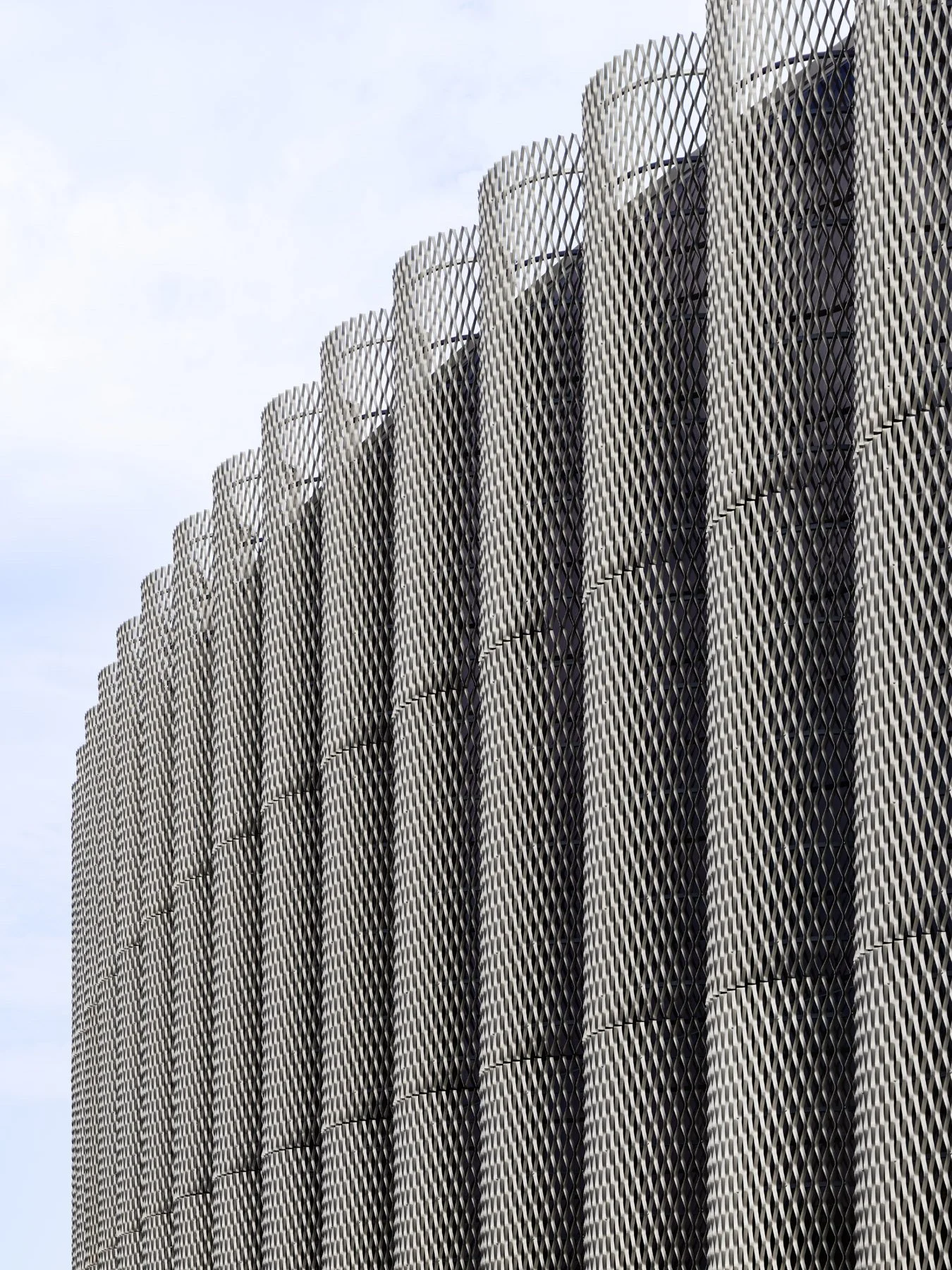 Chicago Park District HQ expanded metal cylindrical screen columns viewed from below against overcast sky, by John Ronan Architects - architectural photographer Chicago Illinois