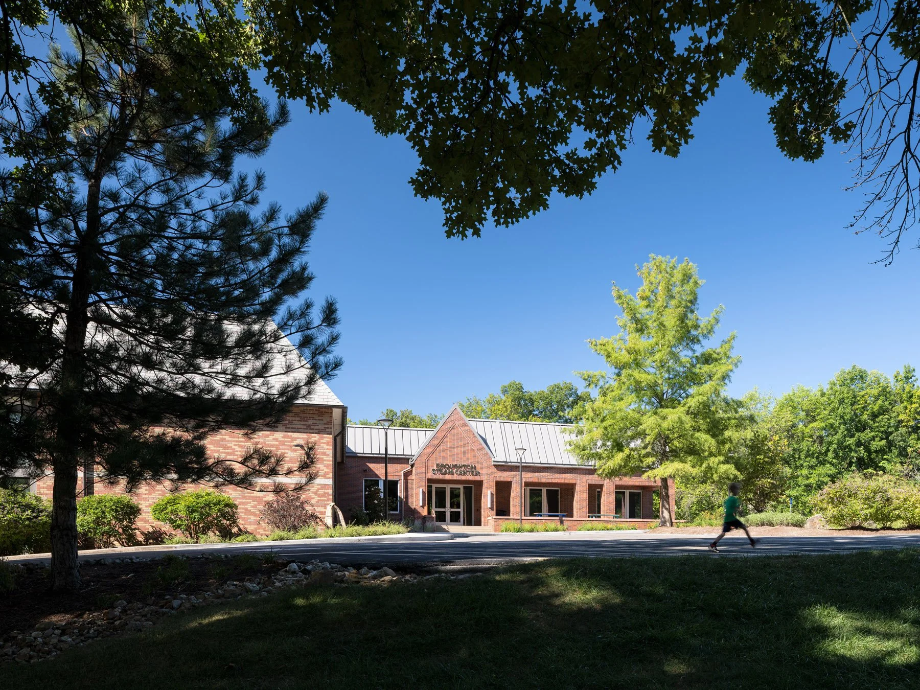 Broughton STEAM Center distant exterior framed by mature trees on the wooded site, by Christner - architectural photographer St. Louis Missouri