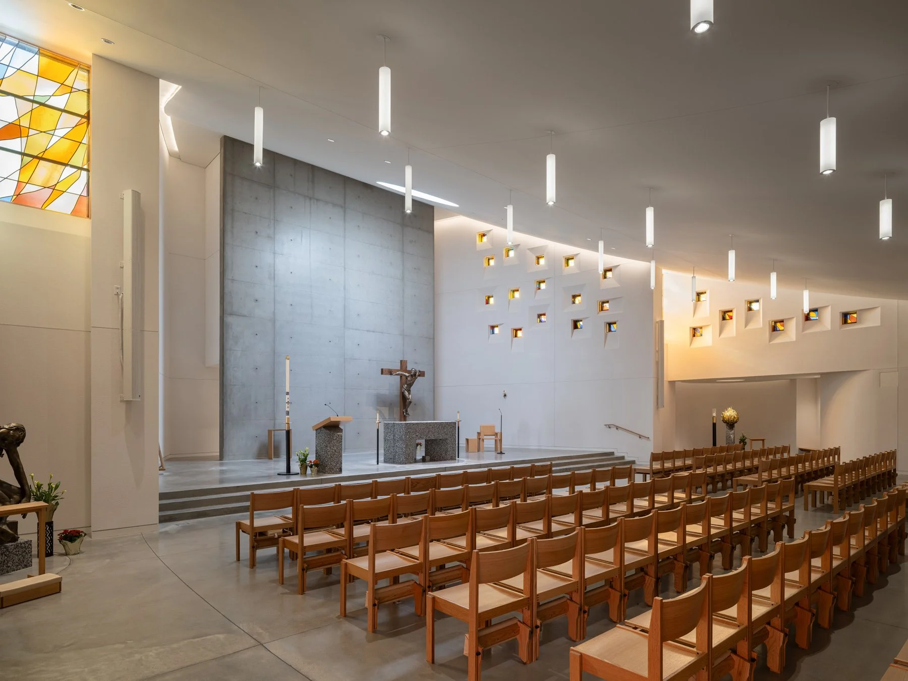 Chapel of the Risen Christ interior nave with wood chairs and altar, by Design Alliance Architects - architectural photographer St. Louis Missouri