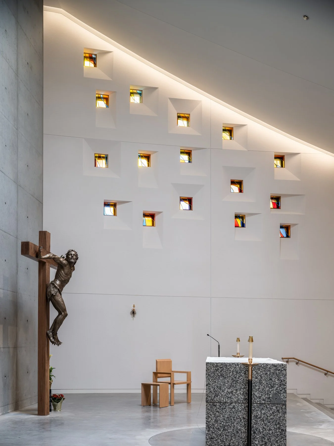 Chapel of the Risen Christ crucifix beside scattered glass apertures, by Design Alliance Architects - architectural photographer St. Louis Missouri