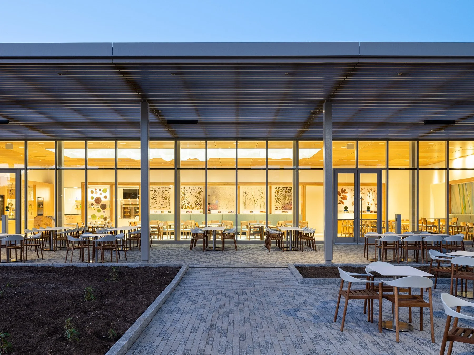 Sassafras Cafe at twilight with patio dining and a glass facade by Ayers Saint Gross - architectural photographer St. Louis Missouri