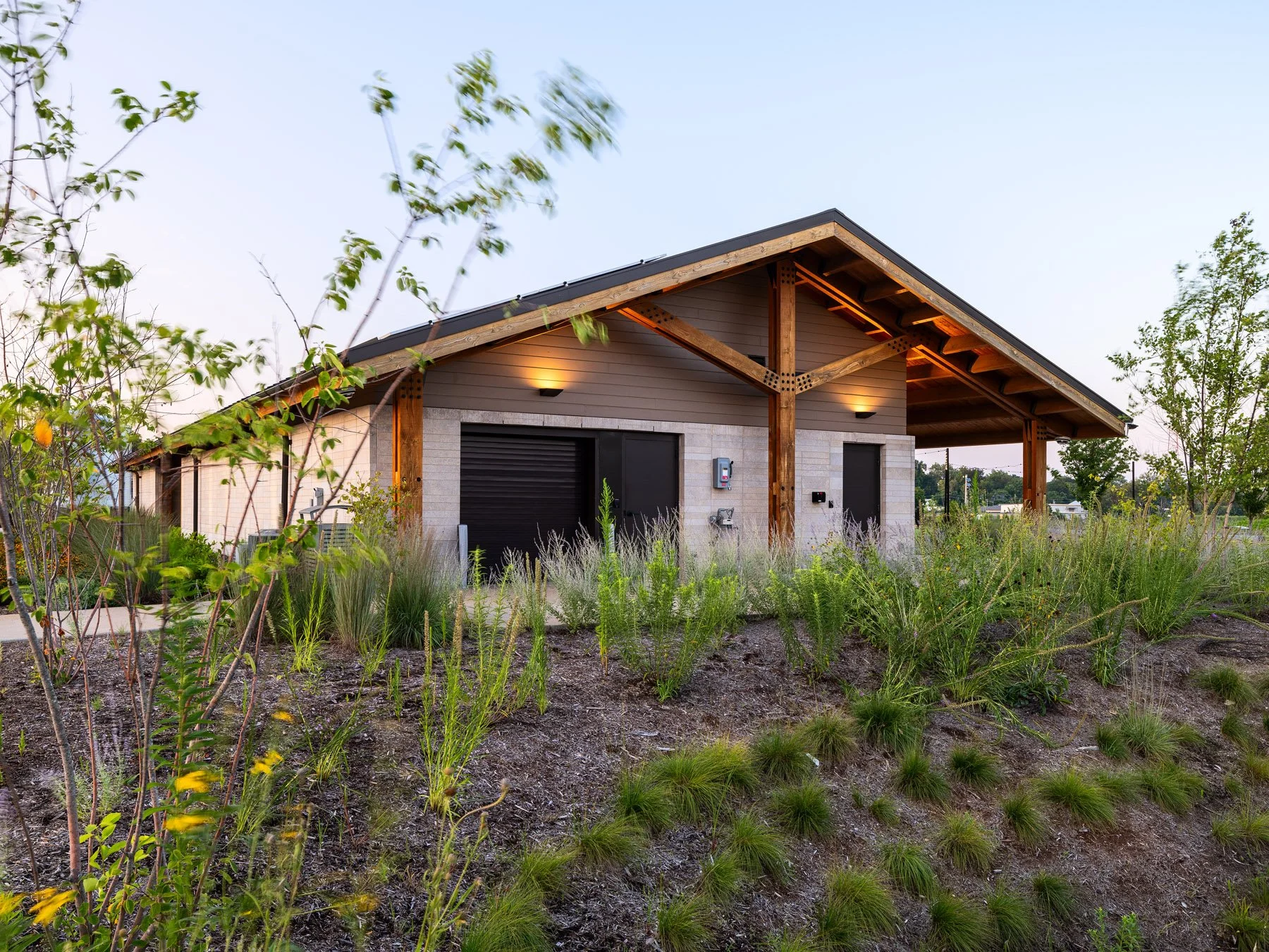 Brentwood Park Event Pavilion utility wing at dusk surrounded by native grasses and plantings, by Christner - architectural photographer St. Louis Missouri
