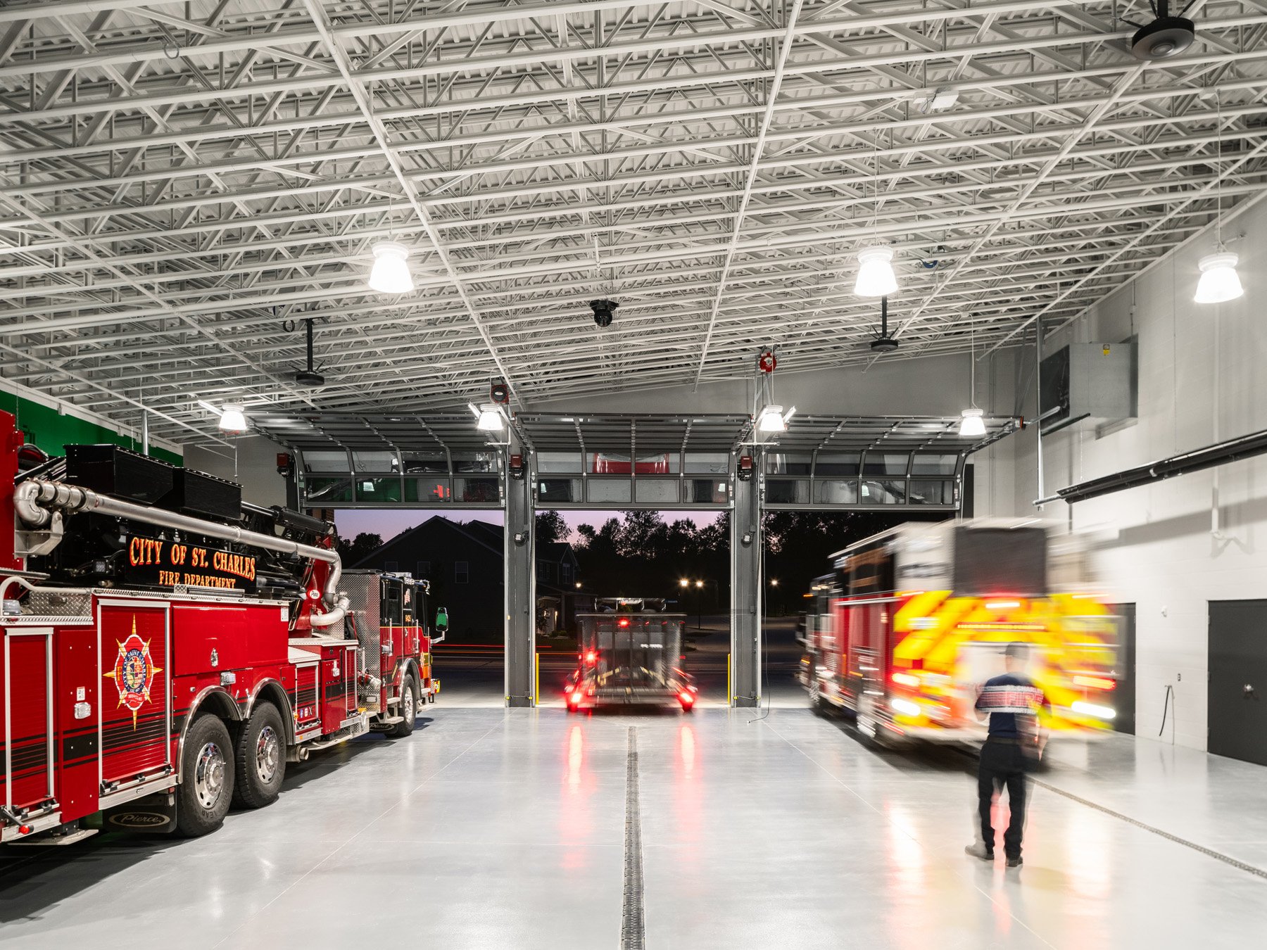 St. Charles fire station apparatus bay at dusk with a departing truck, by JEMA, St. Charles Missouri - architectural photographer St. Louis Missouri