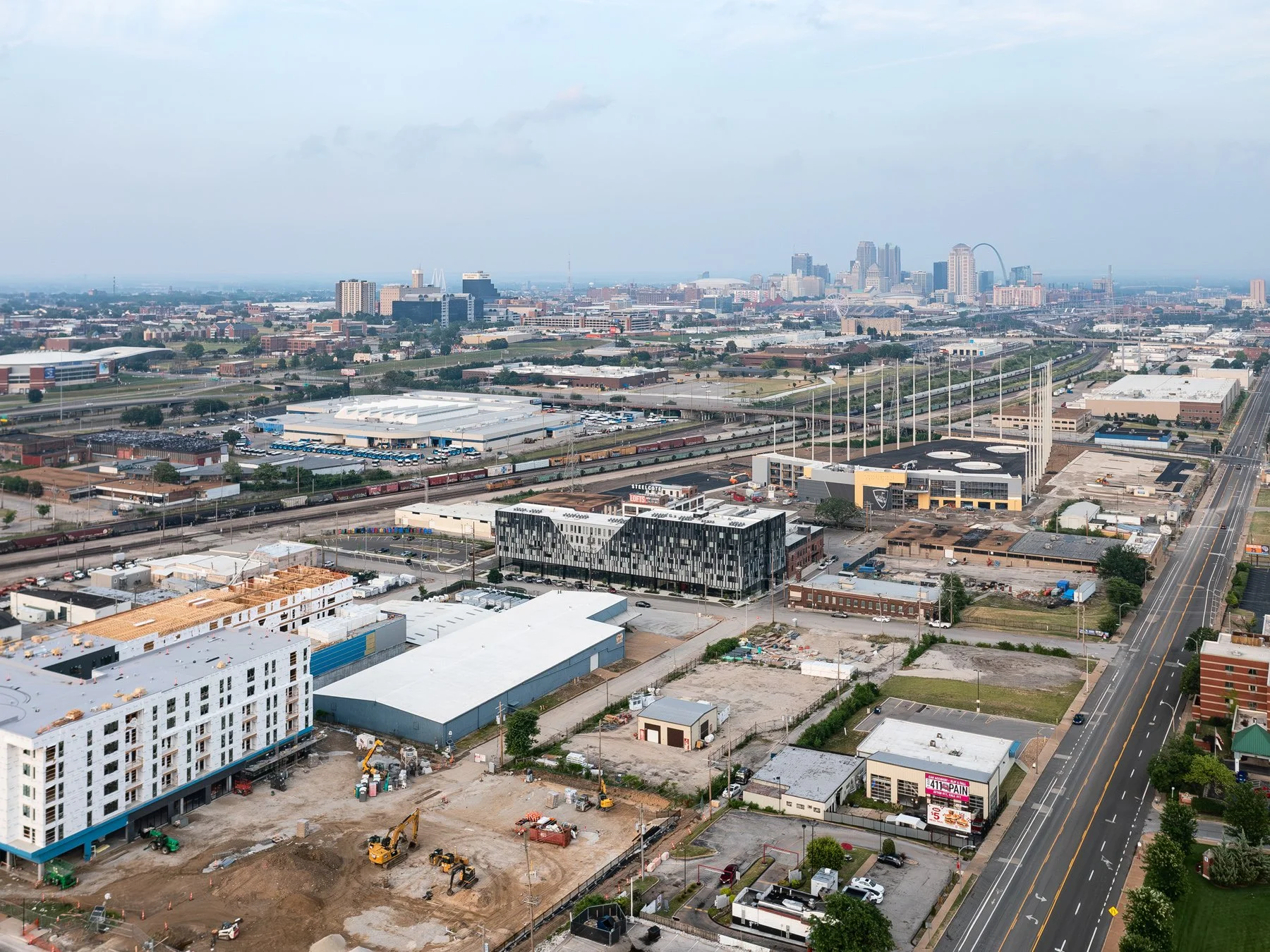 Steelcote Flats aerial over former industrial land toward the downtown skyline and Gateway Arch, by Trivers - architectural photographer St. Louis Missouri