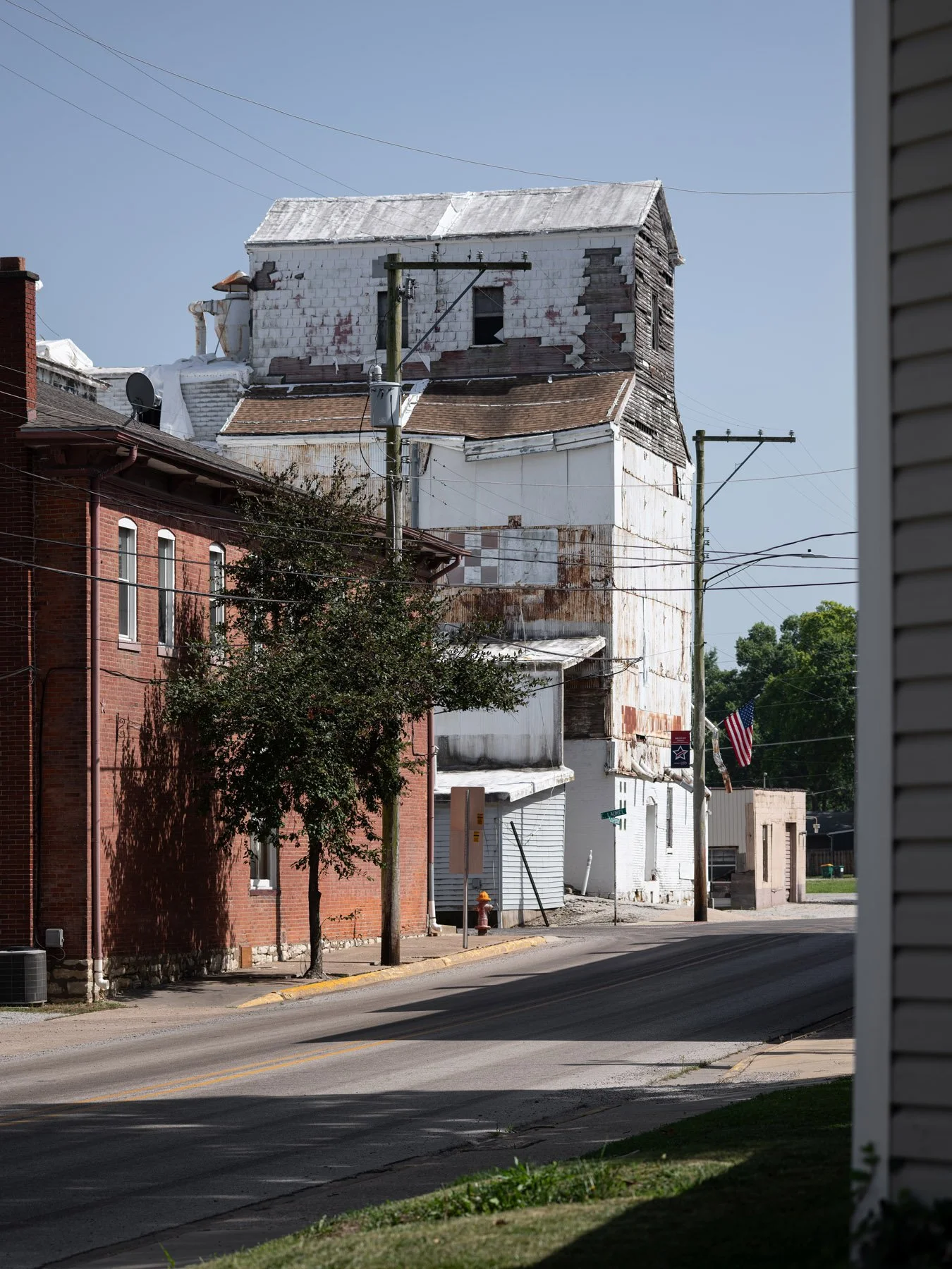 Millstadt Mill rising above the brick storefronts seen down Laurel Street in Millstadt Illinois - architectural photographer St. Louis Missouri