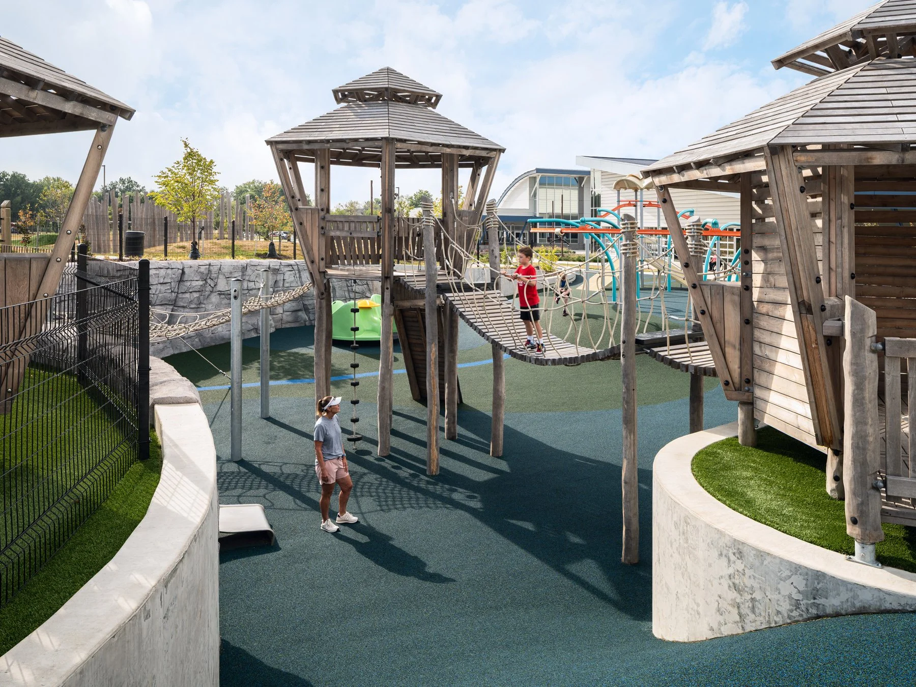 Kinetic Park timber play towers linked by rope bridges over curved walls, landscape by DG2 Design - architectural photographer St. Louis Missouri