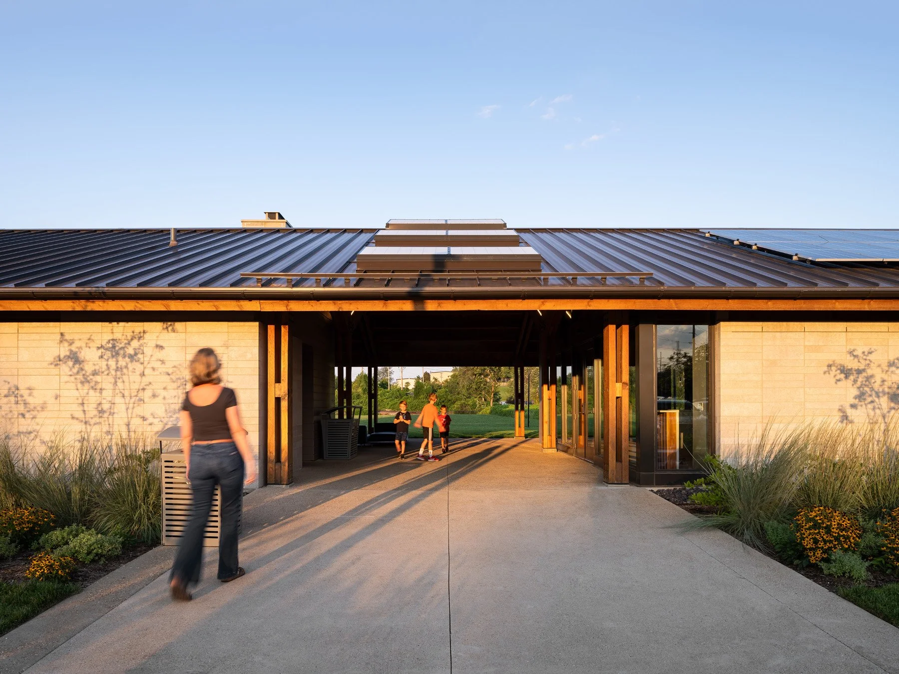 Brentwood Park Event Pavilion breezeway arrival at sunset, heavy-timber frame and solar roof by Christner - architectural photographer St. Louis Missouri
