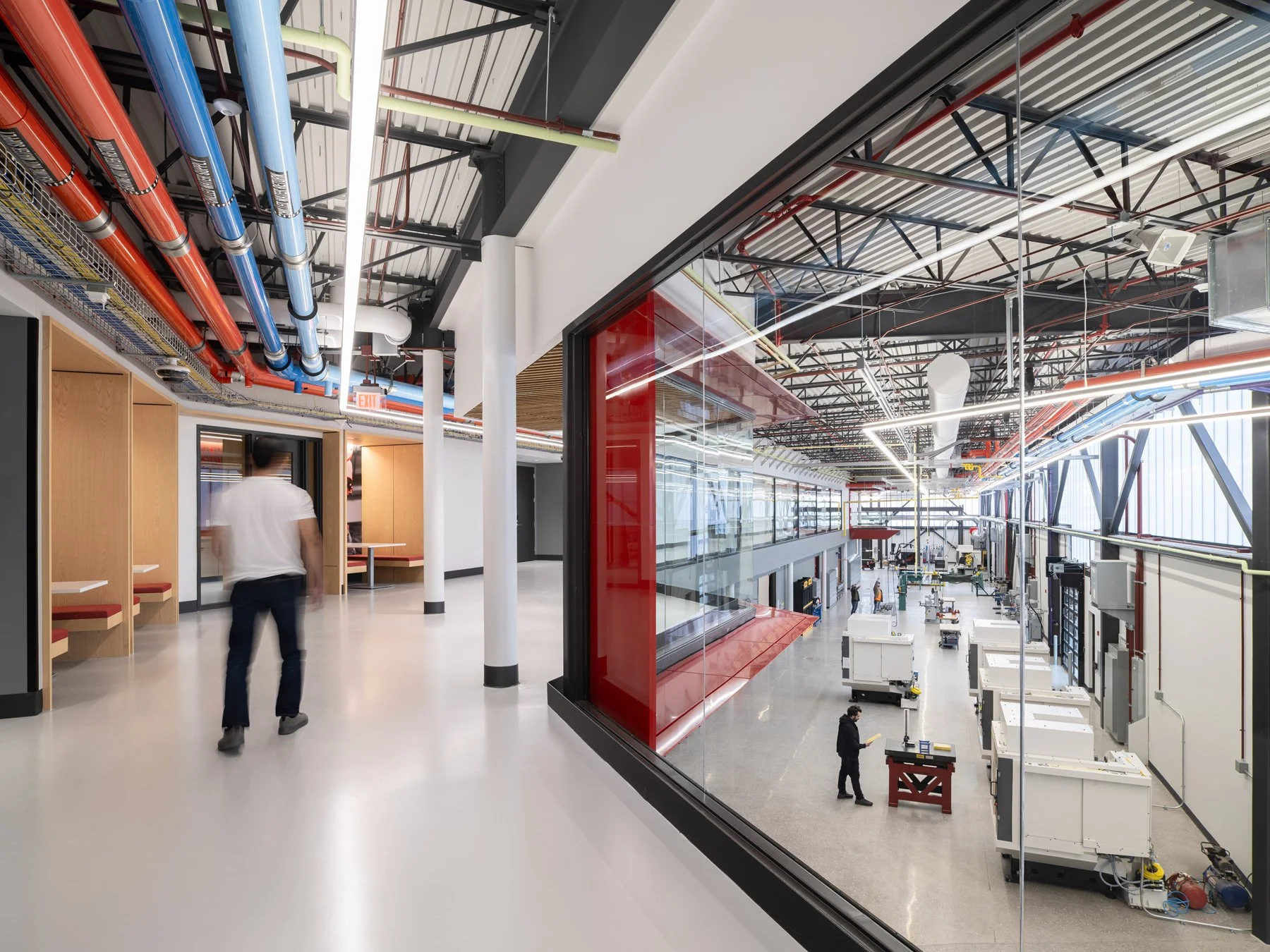 Regional Workforce Innovation Center mezzanine corridor overlooking the machining shop through a red-framed window, St. Charles Community College, Wentzville, Missouri, by JEMA - architectural photographer St. Louis Missouri