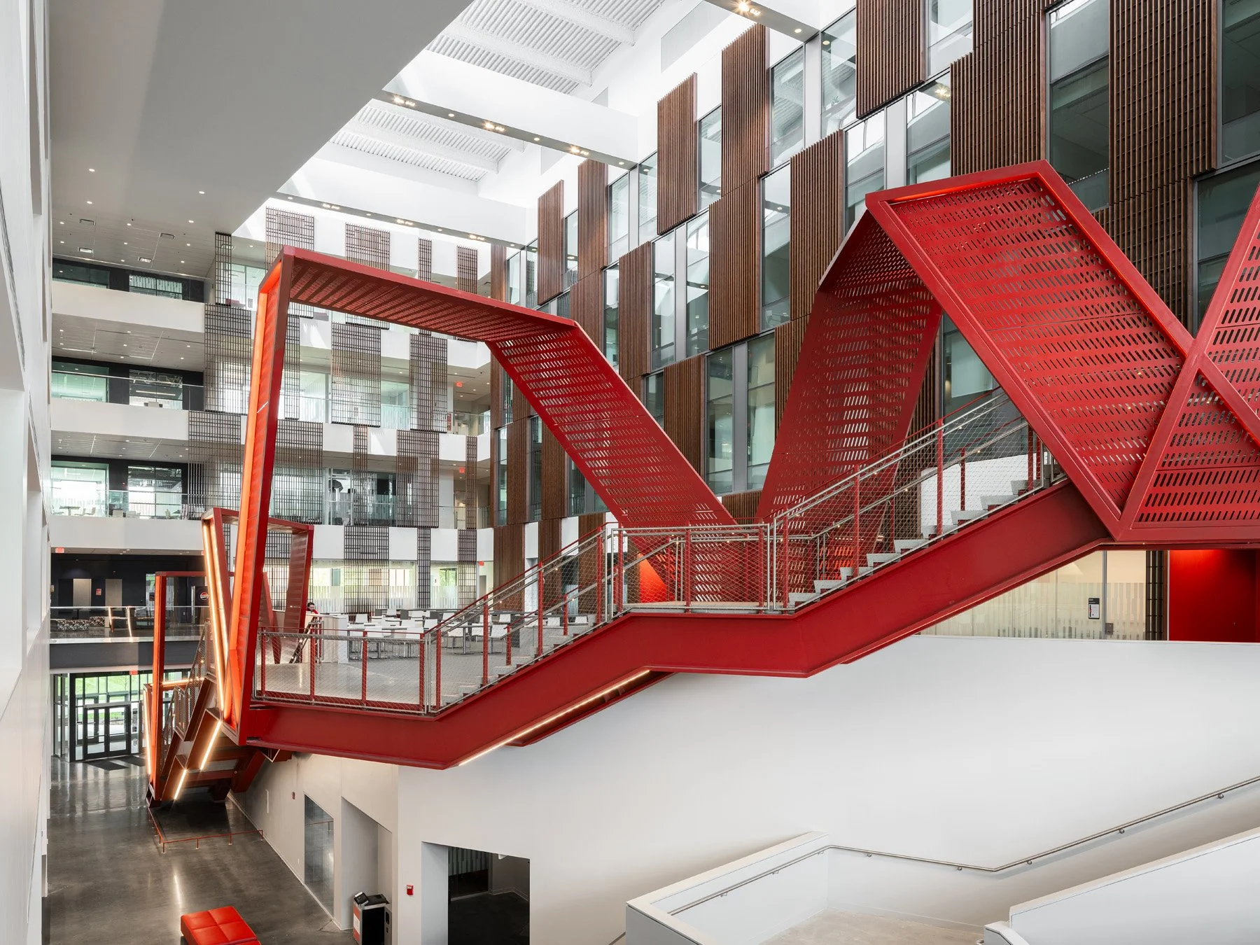 Clifton Court Hall red steel stair bridging the atrium with perforated metal gates, by LMN Architects and KZF Design - architectural photographer Cincinnati Ohio
