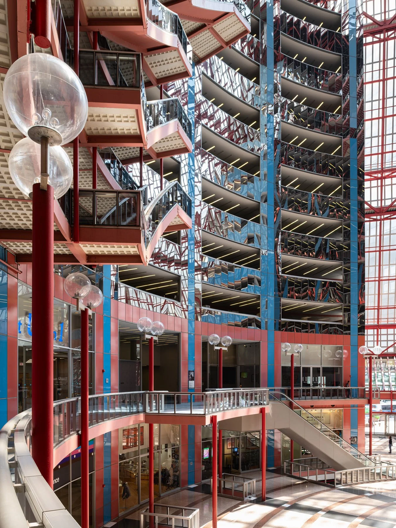 James R. Thompson Center interior, globe lights on red posts before the mirror clad core and tiers, Chicago - Helmut Jahn 1985