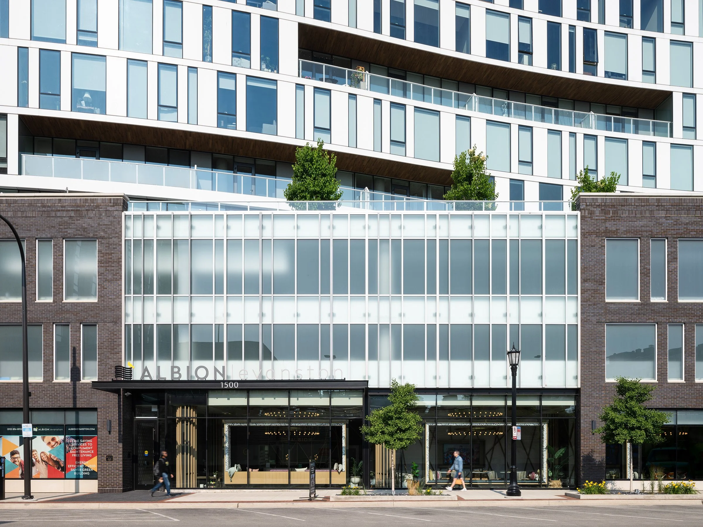 Albion Evanston exterior entrance detail with the 1500 signage and the translucent glass screen set into the brick base, by Hartshorne Plunkard Architecture, Evanston Illinois - architectural photographer Chicago Illinois