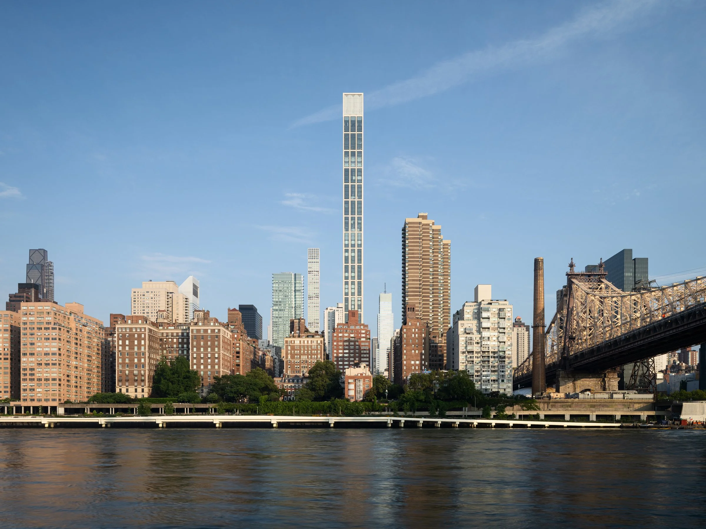 Sutton Tower exterior by day rising on the Manhattan skyline above the East River with the Queensboro Bridge to the right, a slender limestone residential skyscraper by Thomas Juul-Hansen, New York New York - architectural photographer