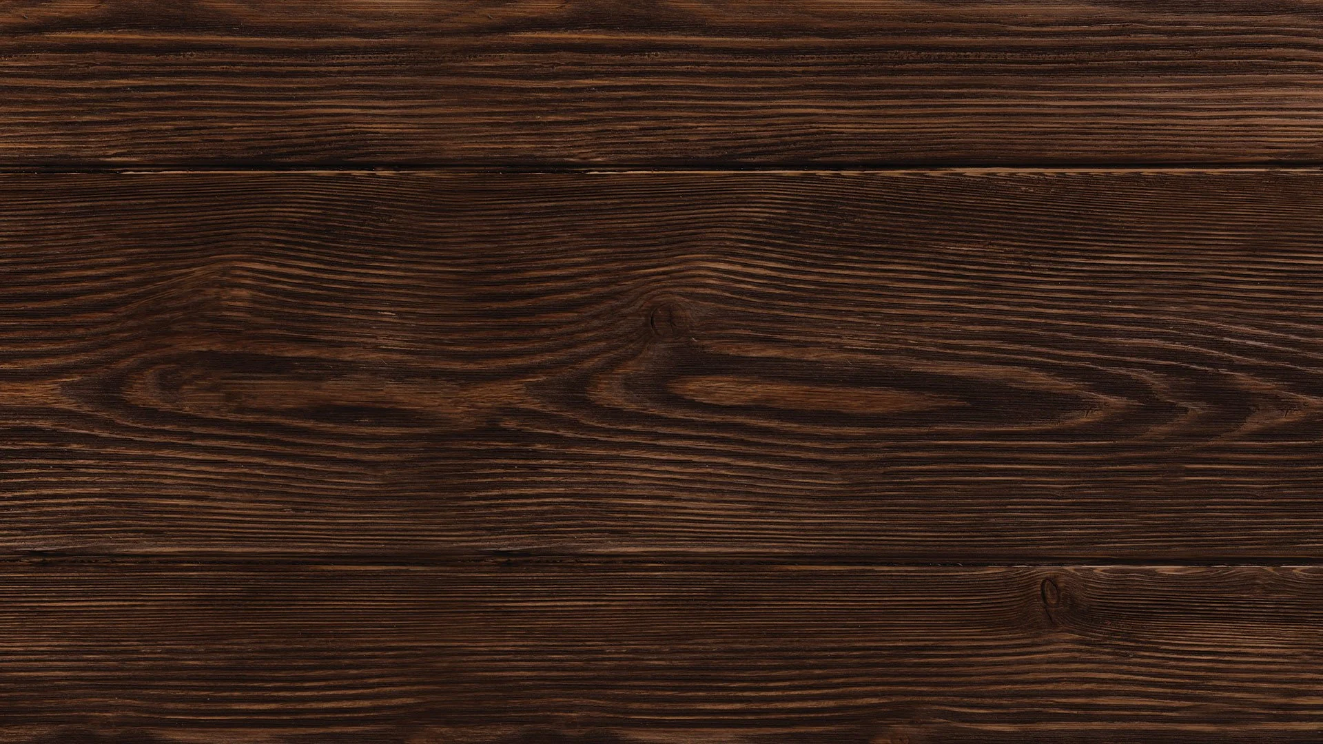 Superfície de madeira marrom escura, com textura visível e veios naturais.