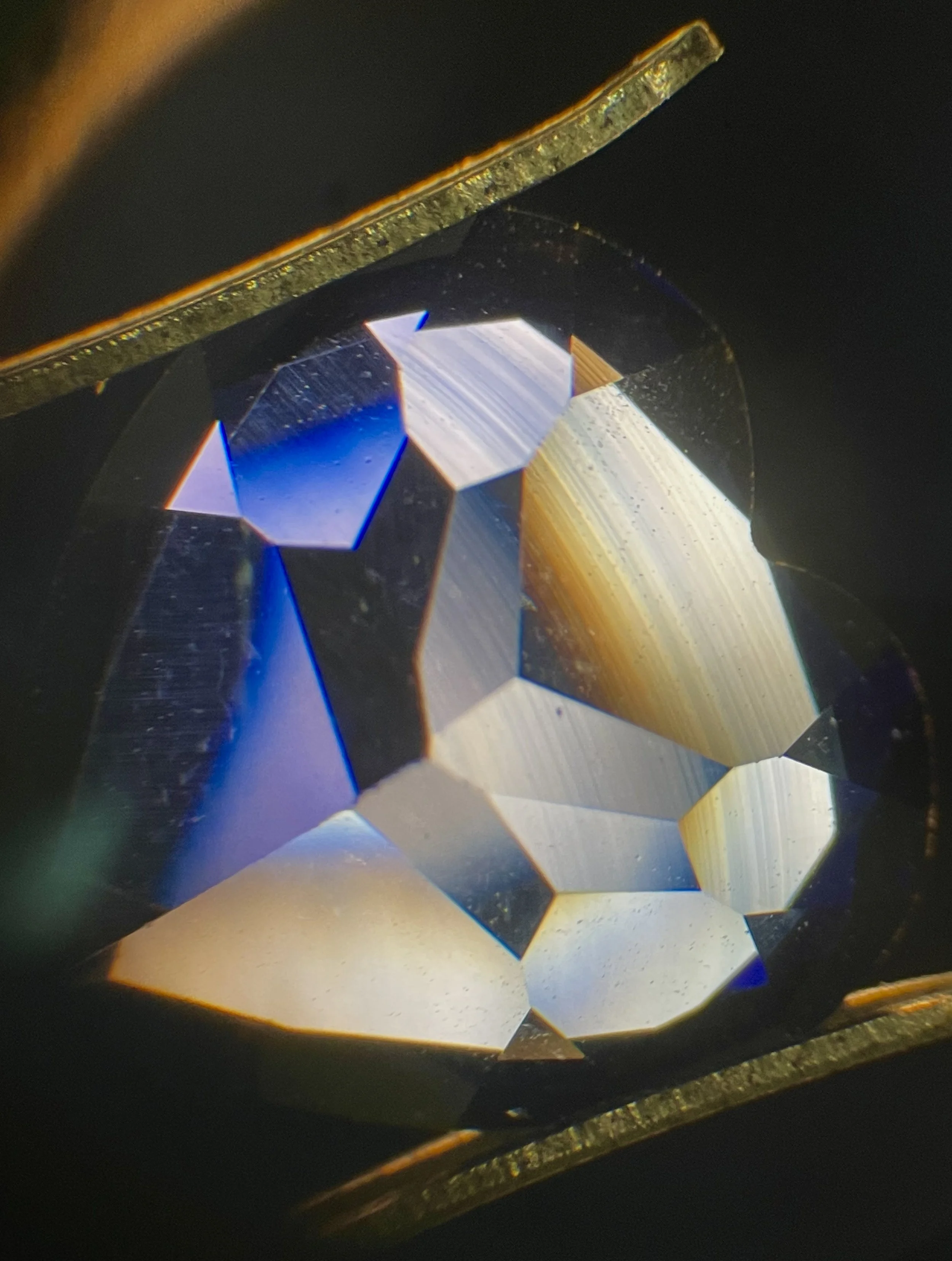 Flame-Fusion Synthetic Sapphire: You will see curved colored banding in this image. Indicating it's synthetic nature.