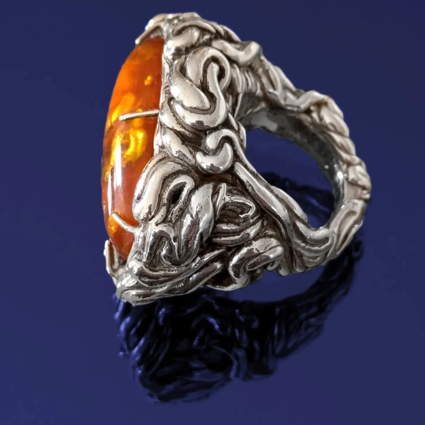 Deep Honey 🐝✨
This custom signet ring, cast in sterling silver, grows from our client’s hand like entwined roots, reaching upward to cradle a large amber cabochon—a treasured gift from her parents.
.
Hidden among the roots are the initia