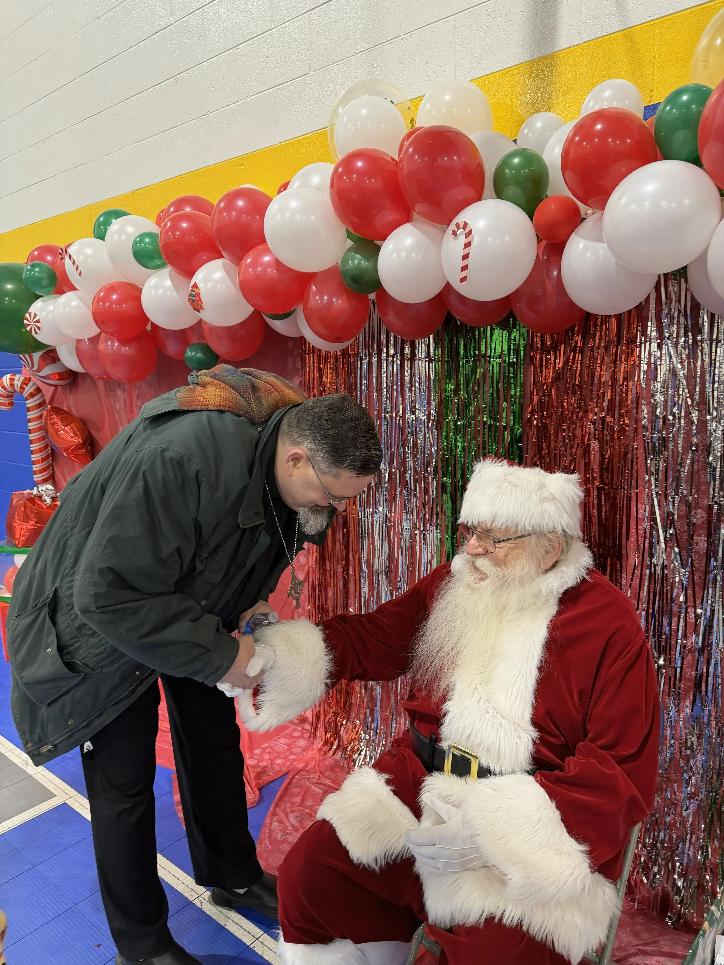 Pastor Reese greets Trinty's special Community Dinner guest: Santa!