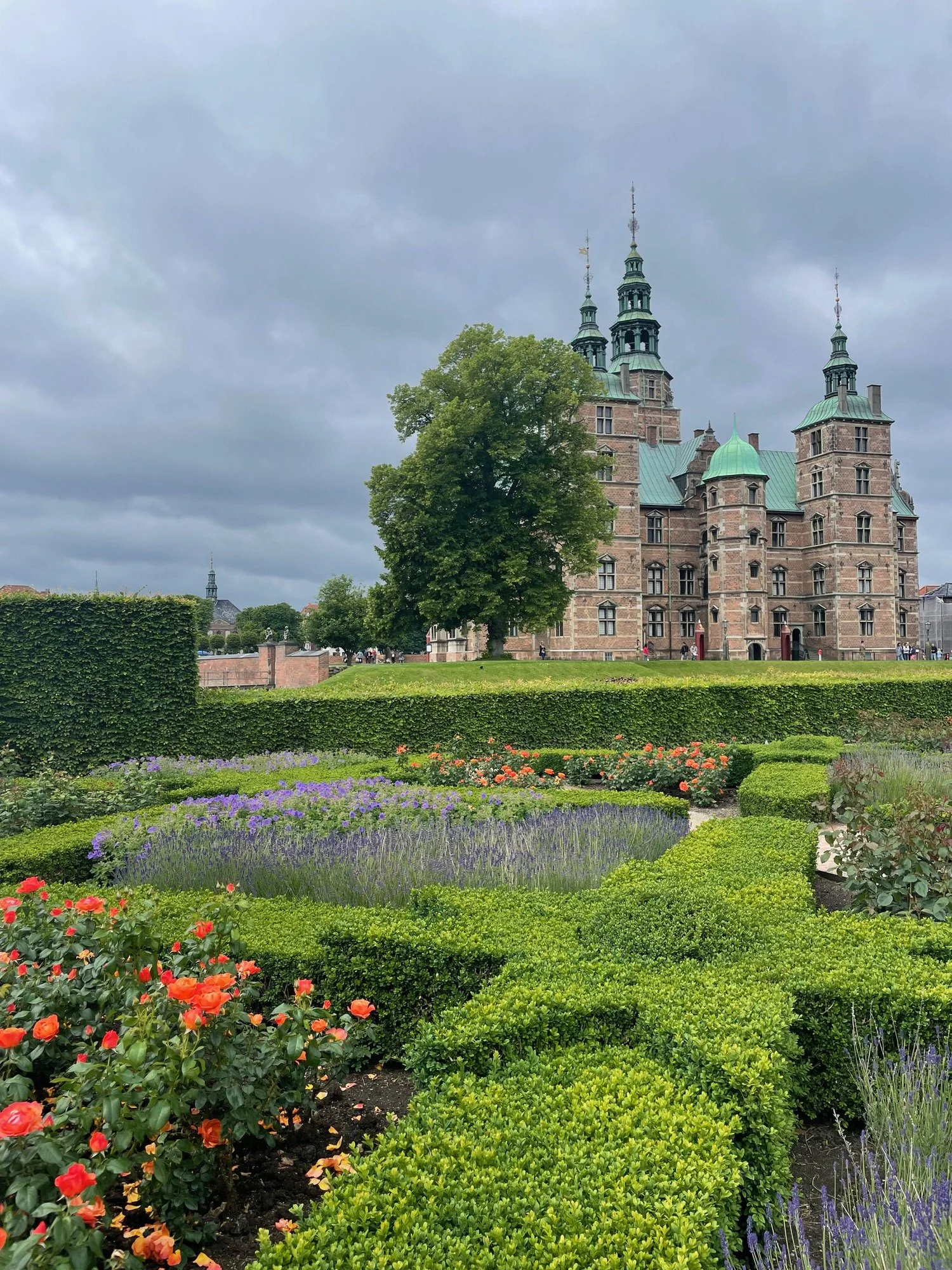 A beautiful view of Rosenborg Palace with the King’s garden in the forefront. On this cloudy day the flowers and greenery shine against the towering palace.