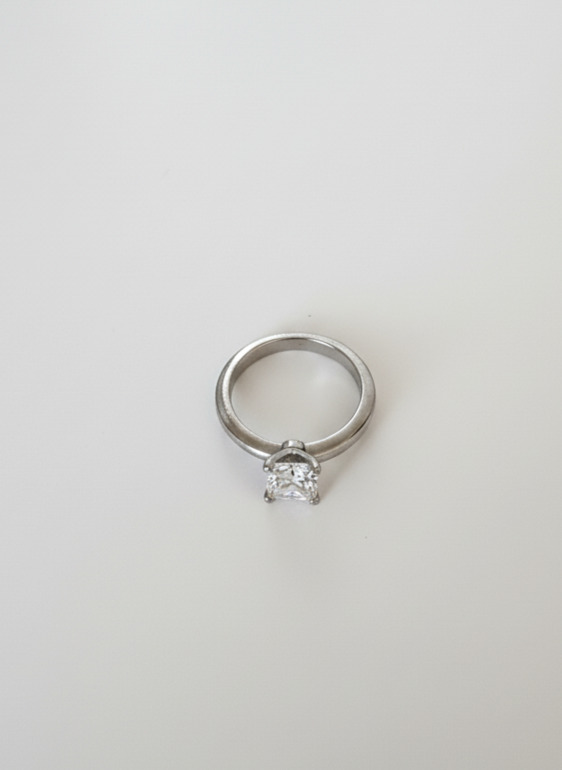 Close-up of a Tiffany diamond solitaire engagement ring on a simple white background by Richer Jewelry