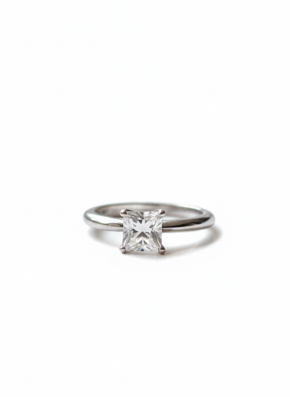 Close-up of a Tiffany diamond solitaire engagement ring on a simple white background by Richer Jewelry