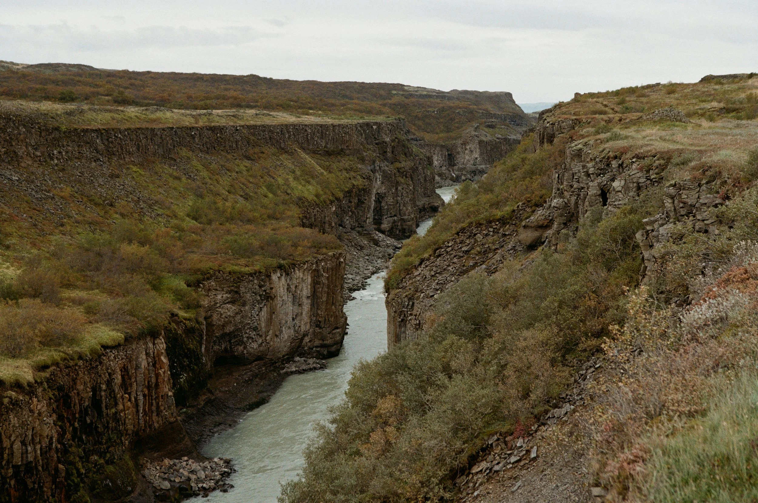 Ein Fluss, der durch eine schmale Schlucht mit steilen, bewaldeten Felswänden fließt.