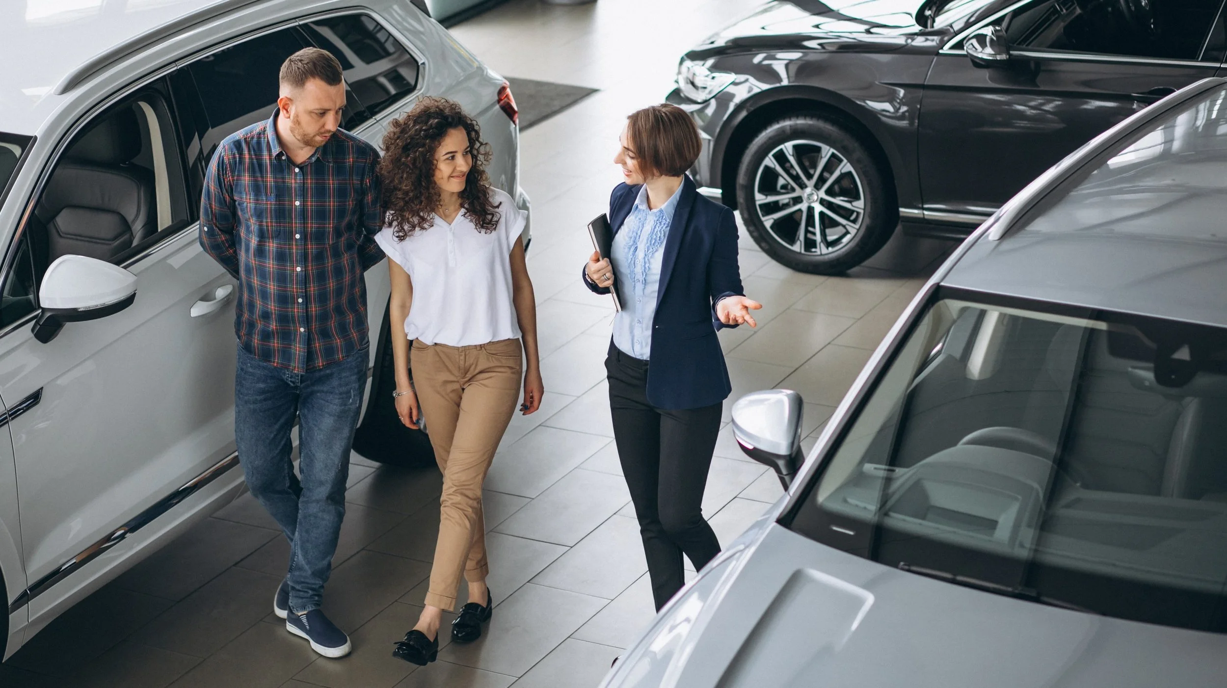 young-couple-talking-sales-person-car-showroom.jpg