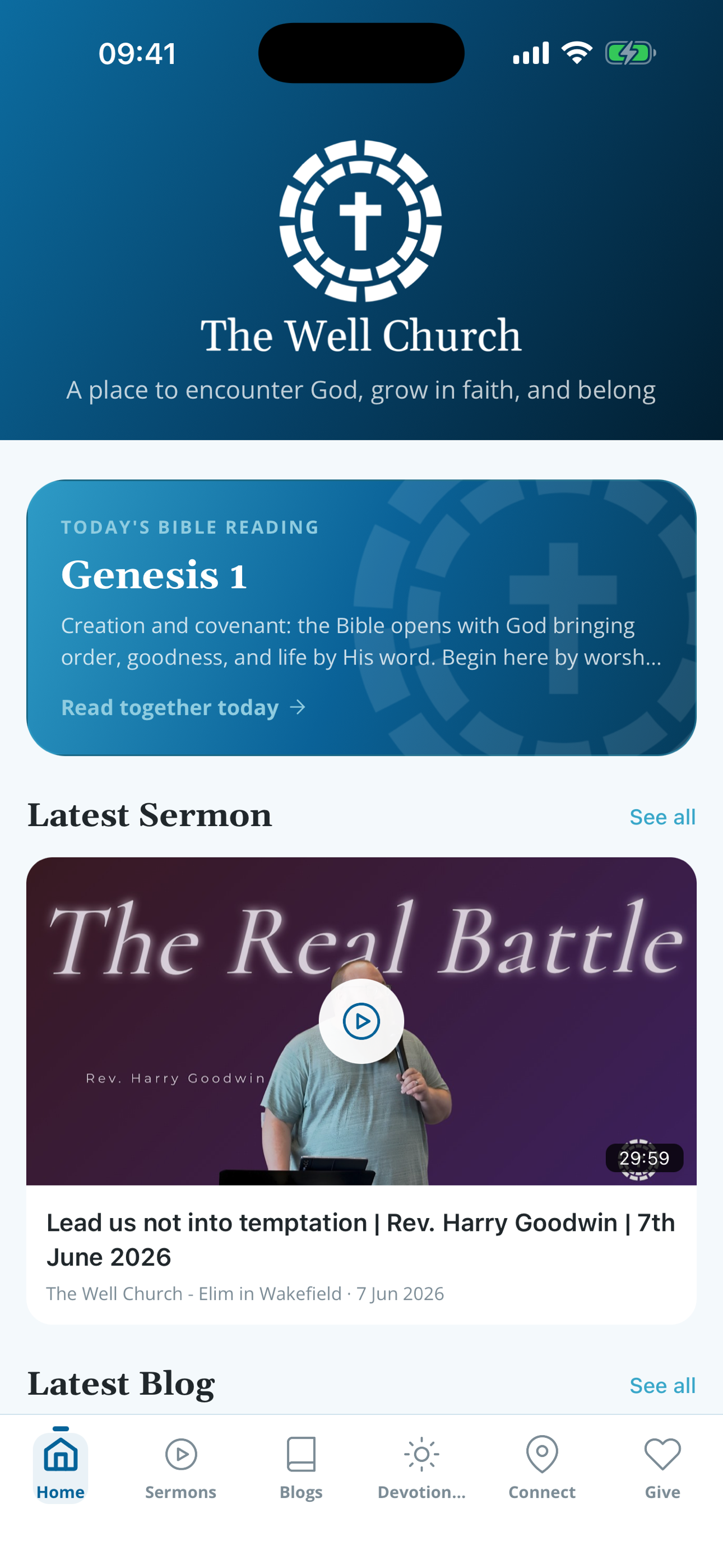 Mobile app home screen of The Well Church featuring a logo, Bible reading plan for Genesis 1, latest sermon video titled 'The Real Battle' by Rev. Harry Goodwin, and navigation menu at the bottom.